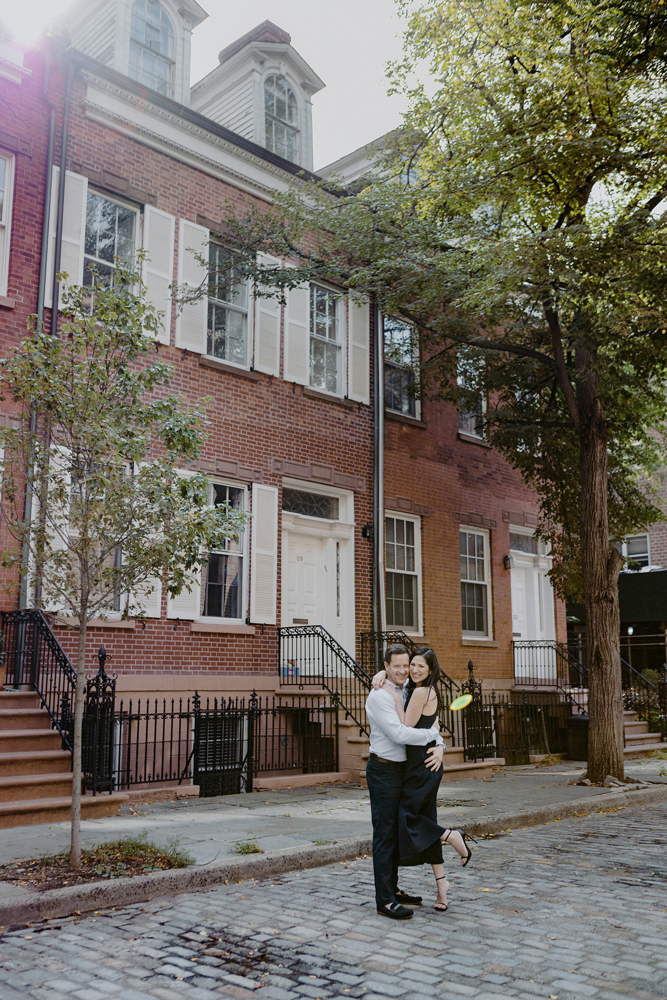 The engaged couple is hugging each other at West Village, NYC. Editorial Summer engagement image by Jenny Fu Studio