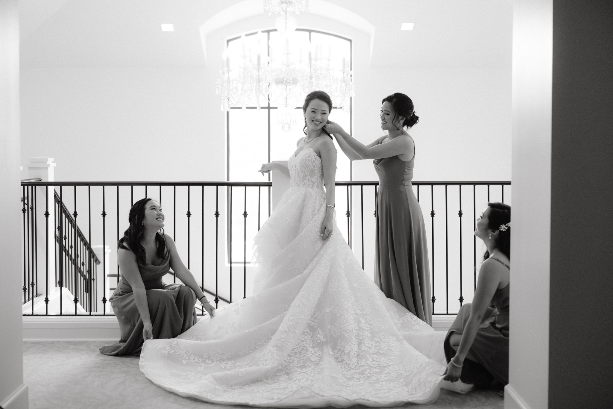 The bridesmaids are fixing the bride's dress and hair before the wedding. Wedding venue image by Jenny Fu Studio