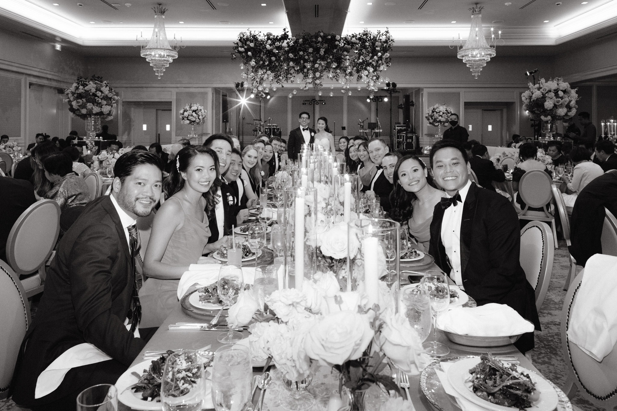 Black and white image of the happy guests seated on the dining table in the wedding reception. Wedding venue image by Jenny Fu Studio