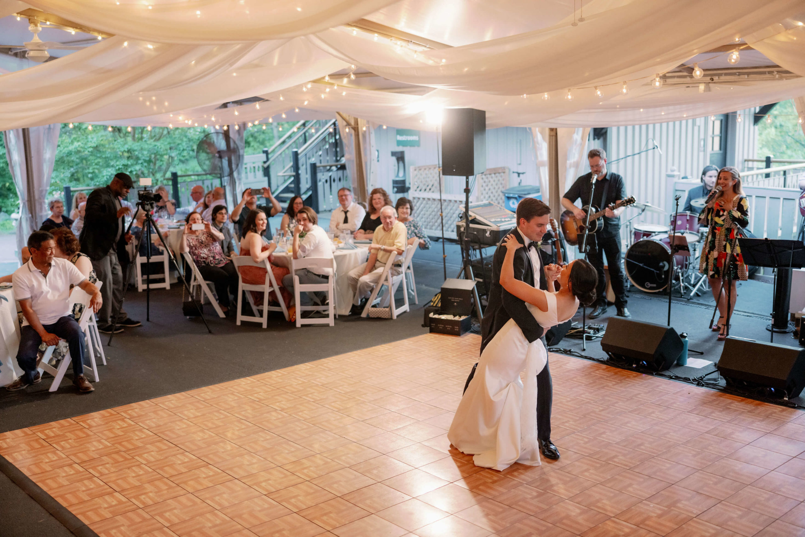 The bride and groom are dancing on the dance floor as the guests watch and the band play. Destination wedding image by Jenny Fu Studio