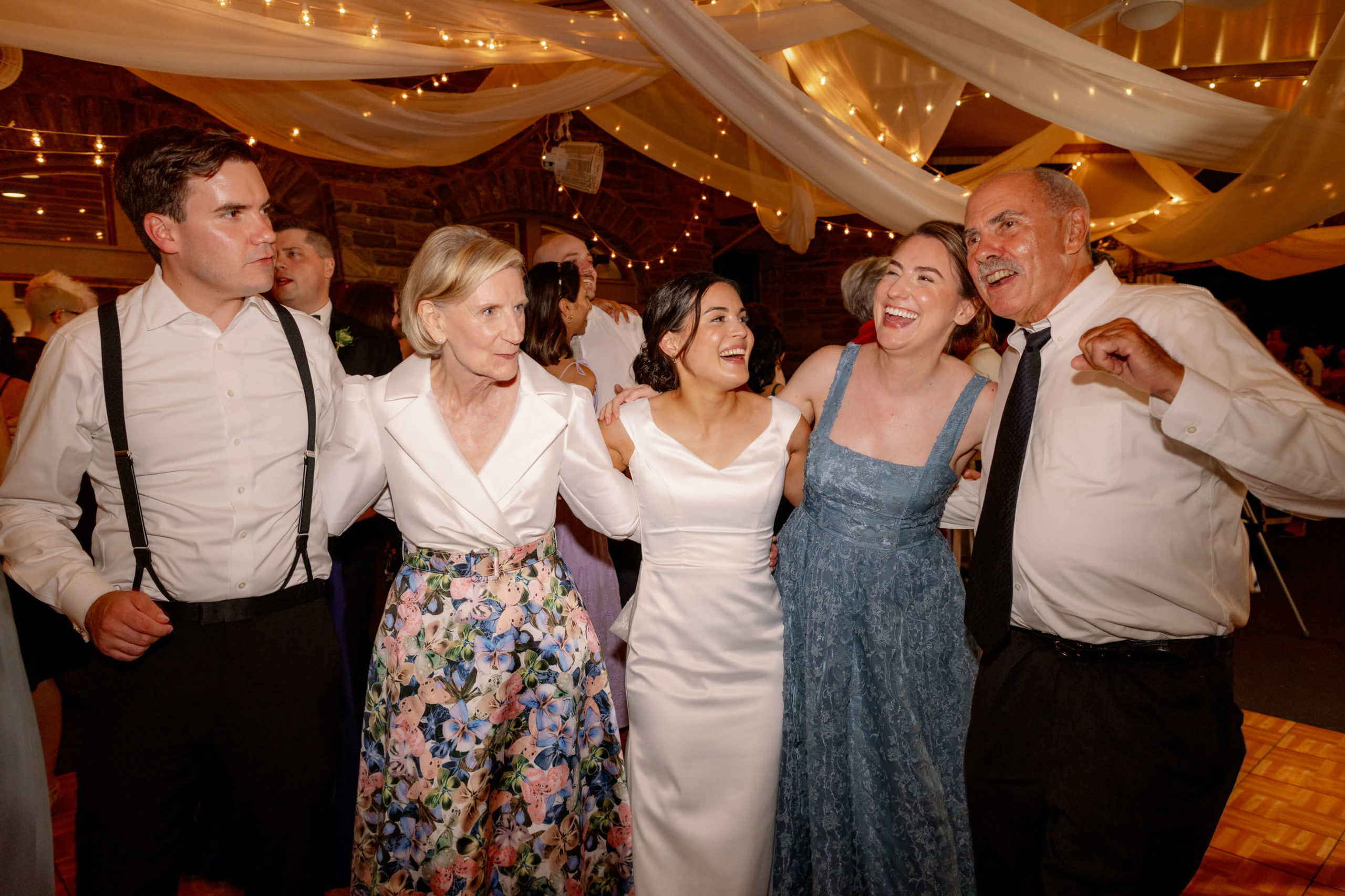 The bride, groom, and guests are happily dancing the night away. Destination wedding image by Jenny Fu Studio