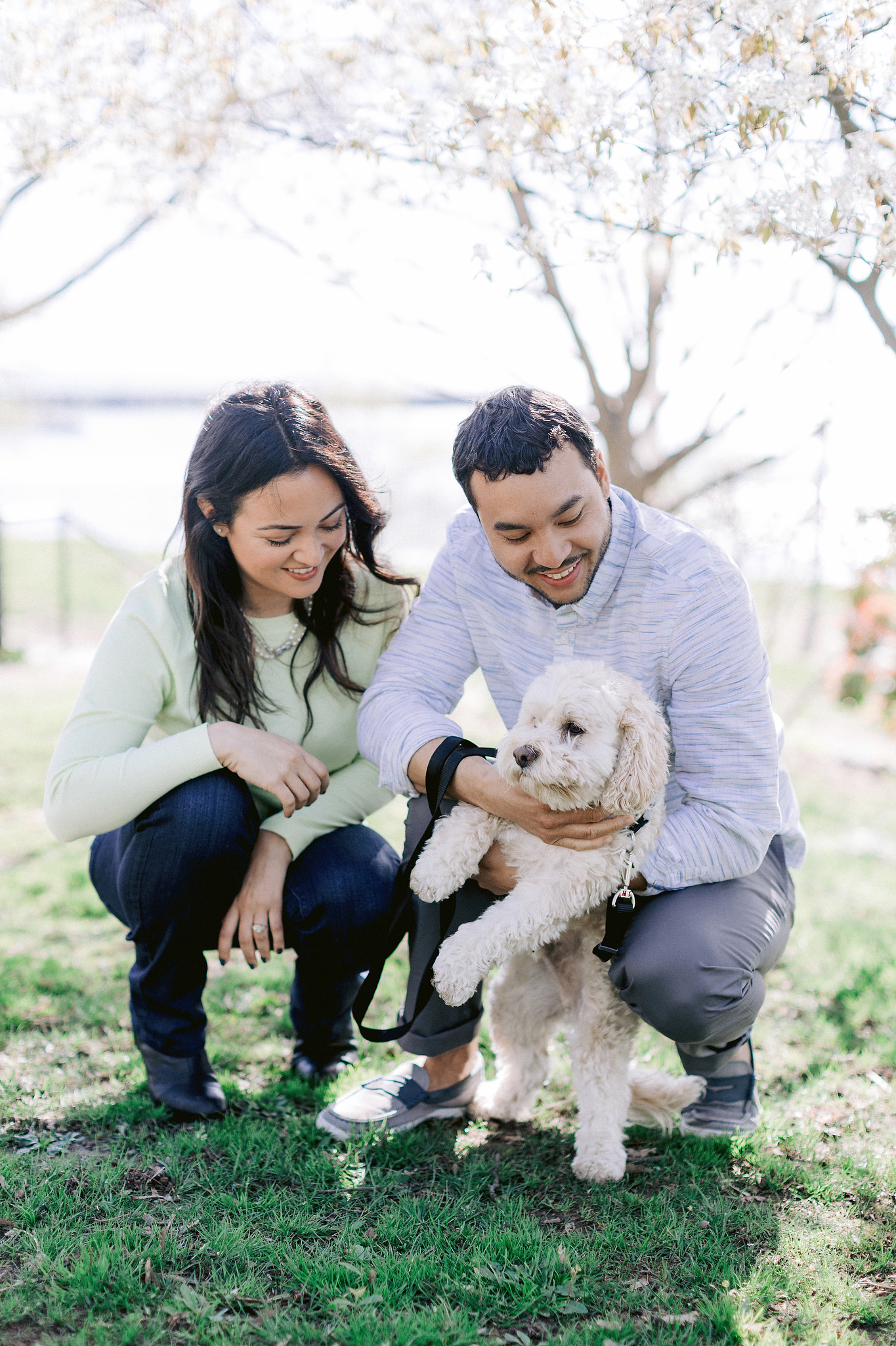 The engaged couple is cuddling their dog. Image by Jenny Fu Studio