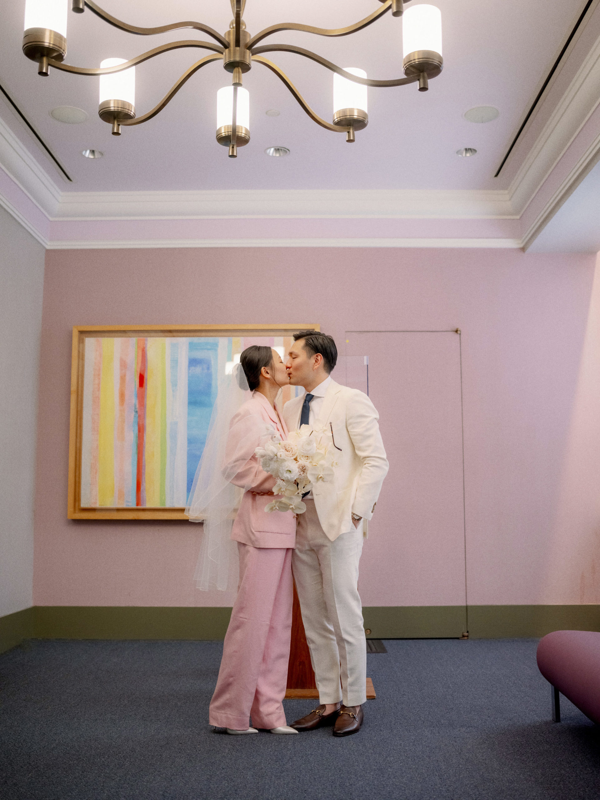 The bride and groom are kissing after the wedding ceremony at NYC City Hall. Editorial elopement image by Jenny Fu Studio.