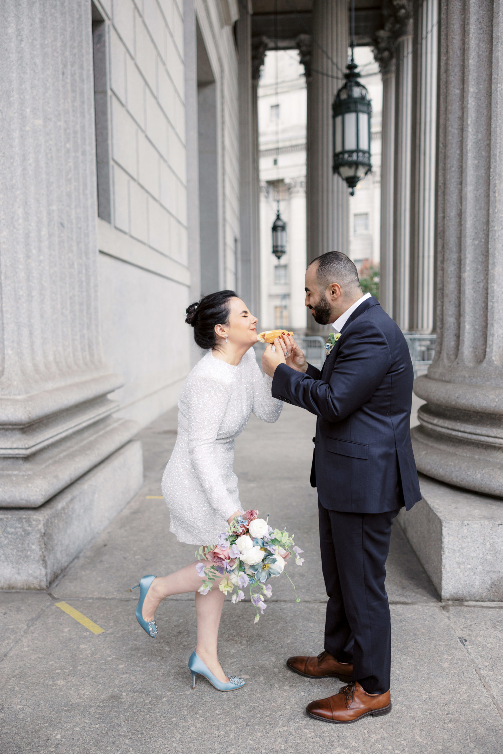 The newly-weds are having a fun time eating hotdogs after their NYC City Hall wedding. Image by Jenny Fu Studio