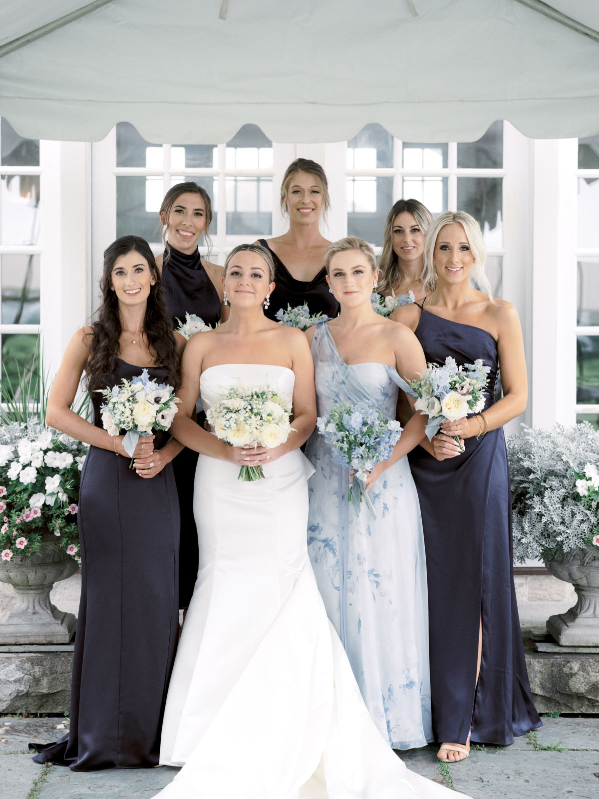 The bride and her bridesmaids are holding their flower bouquets. Editorial wedding image by Jenny Fu Studio