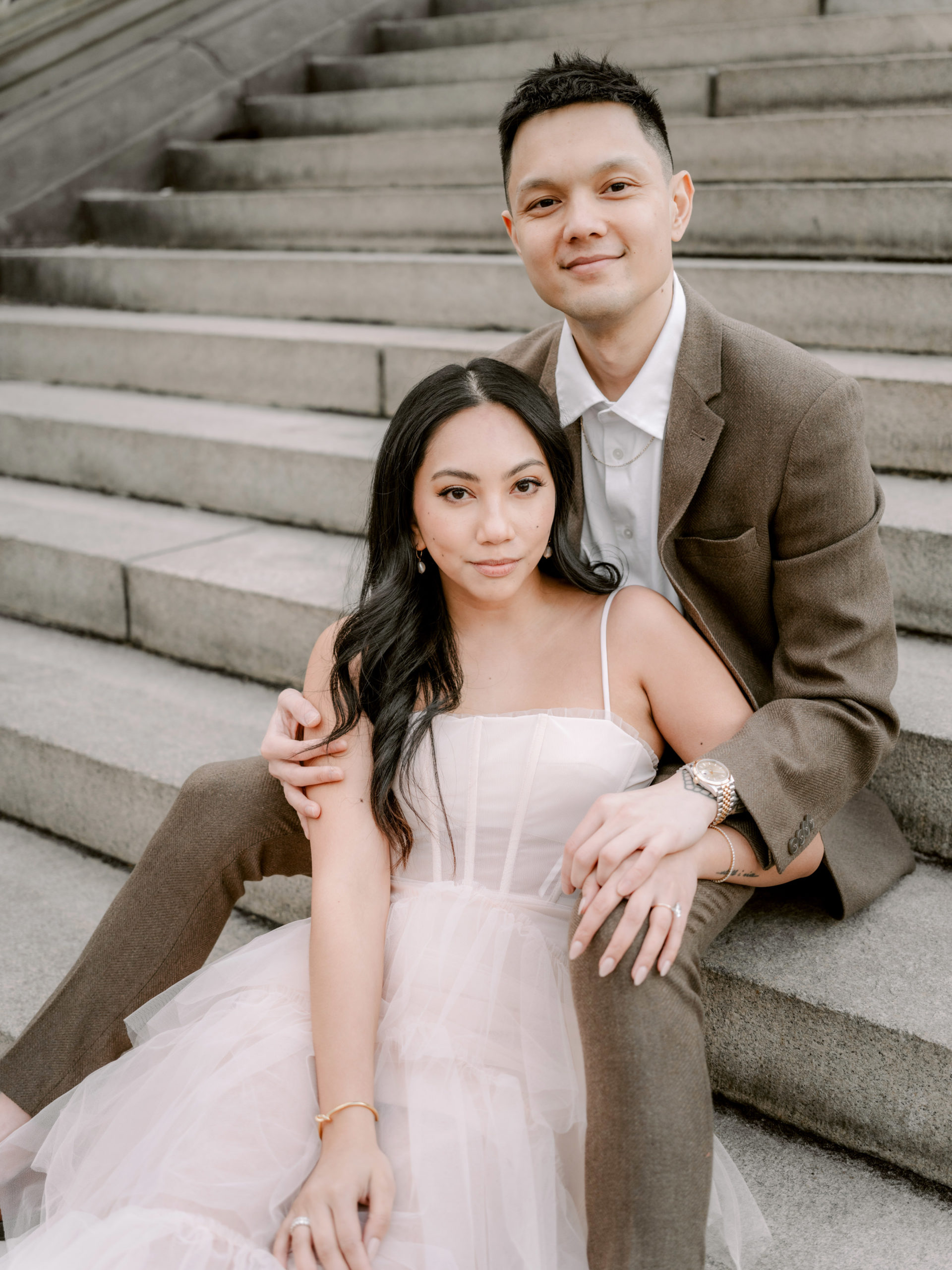 The engaged couple are sitting on a staircase at New York Central Park. Editorial Photography by Jenny Fu Studio