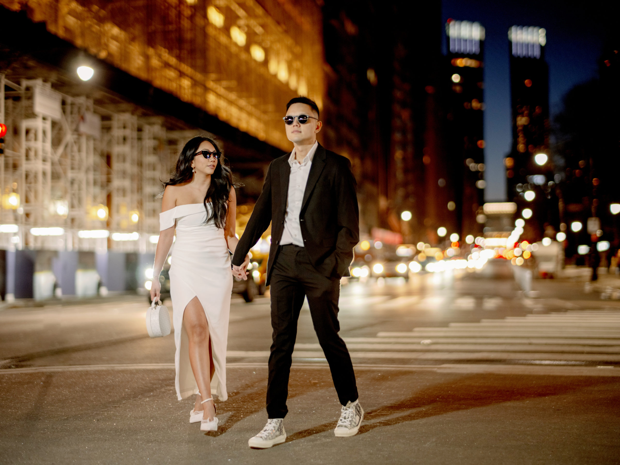 The engaged couple are wearing sunglasses in the streets of New York in the night. Photojournalistic Engagement image by Jenny Fu Studio
