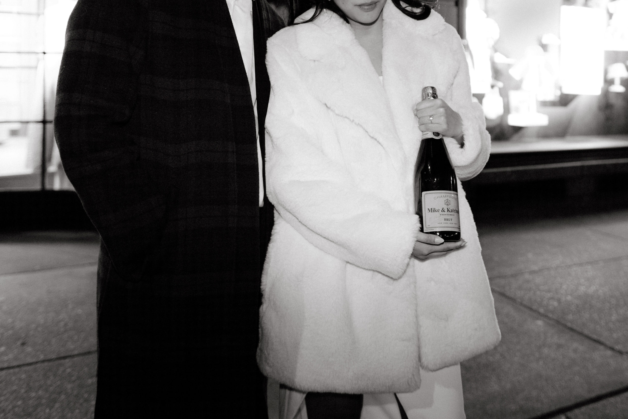 Black and white image of the engaged couple holding a bottle of wine. Photojournalistic Engagement image by Jenny Fu Studio