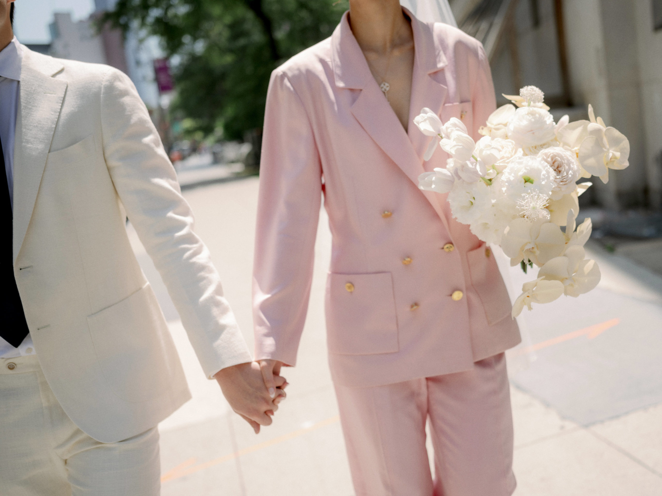 The bride is wearing a pink wedding suit for her city hall wedding. Editorial elopement Image by Jenny Fu Studio