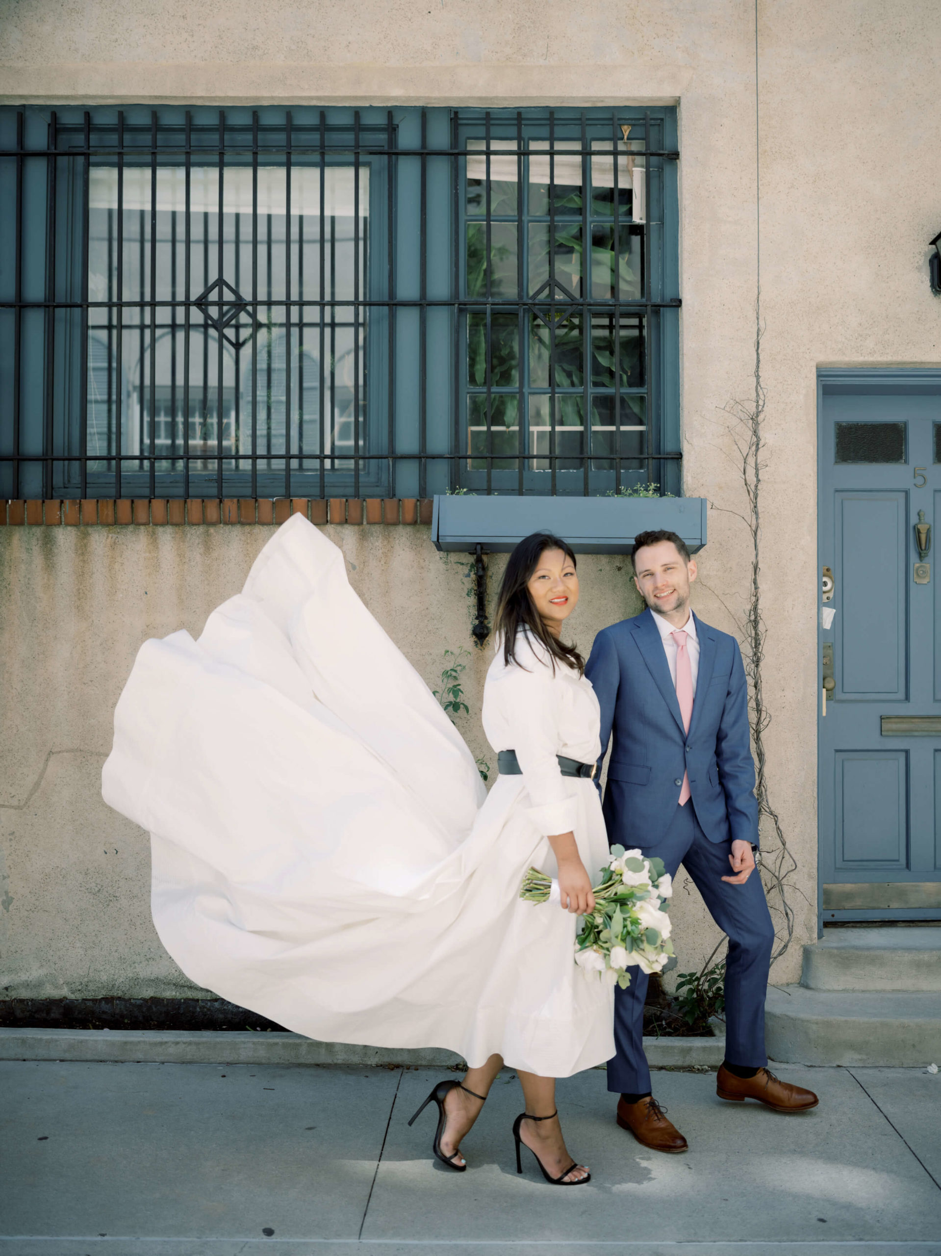 The newly-weds are walking in the streets of NYC after their city hall wedding. Editorial elopement Image by Jenny Fu Studio