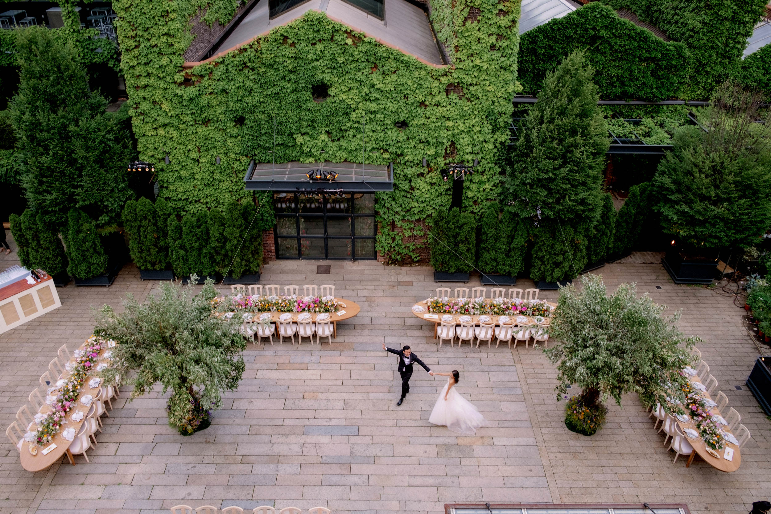 The bride and groom are dancing in the middle of the outdoor wedding venue. 