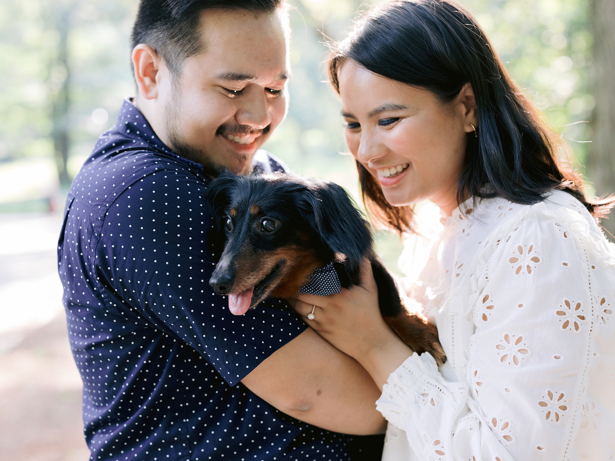 The engaged couple is hugging their dog. Editorial engagement photo image by Jenny Fu Studio