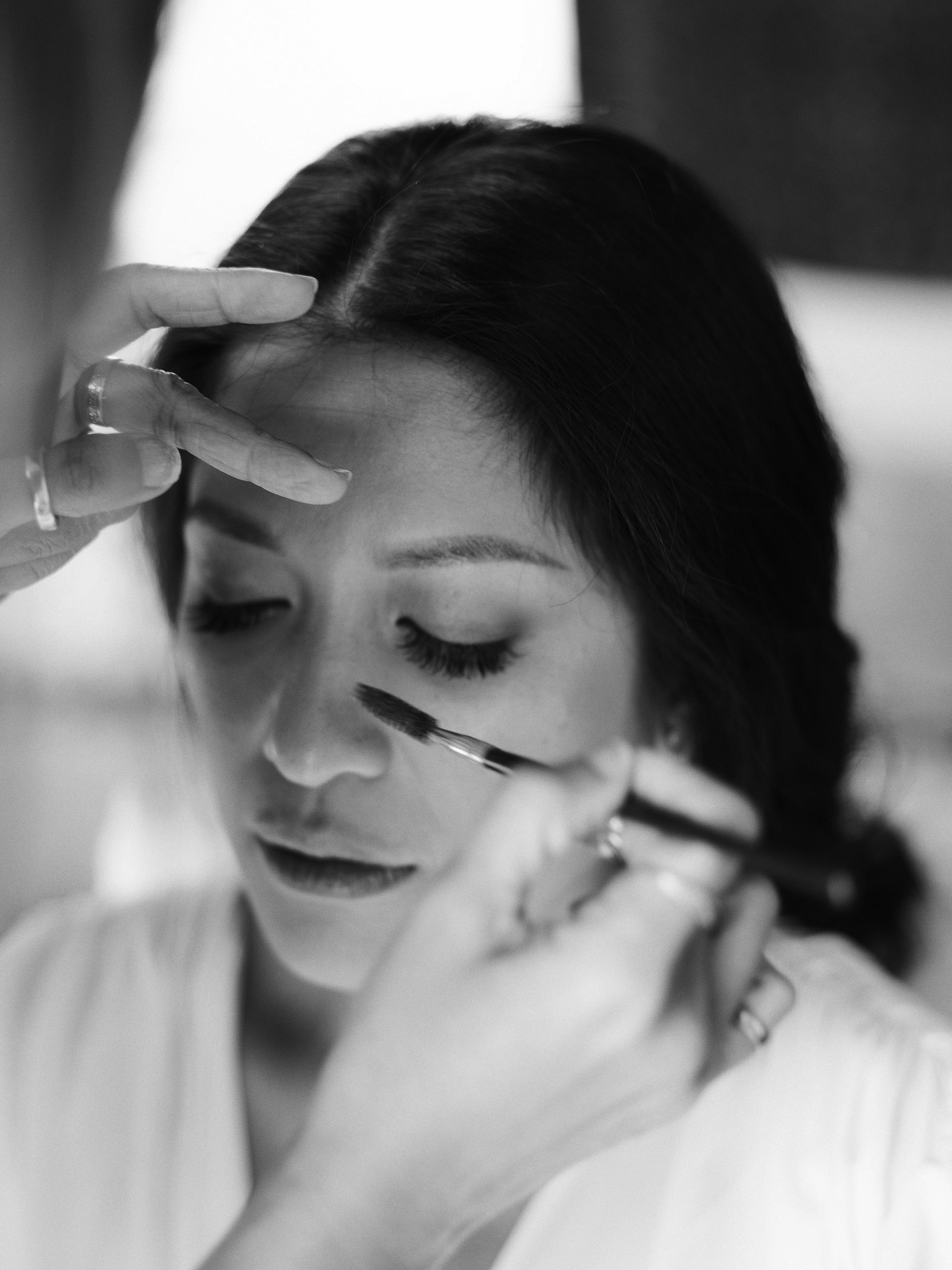 Make-up is being applied to the bride. Editorial destination wedding photo by Jenny Fu Studio