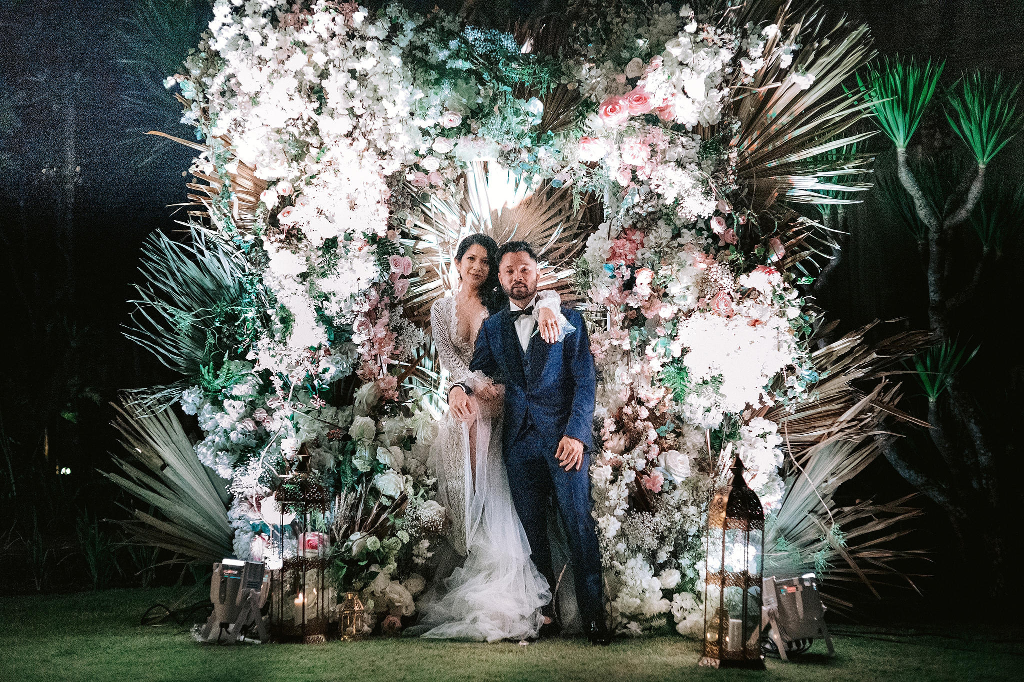The newlyweds look gorgeous amidst the large floral arrangement at Bali, Indonesia.