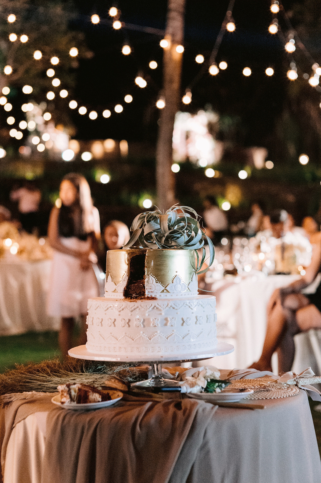 A beautiful 2-layered wedding cake with gold and white colors at a wedding in Bali, Indonesia. 
