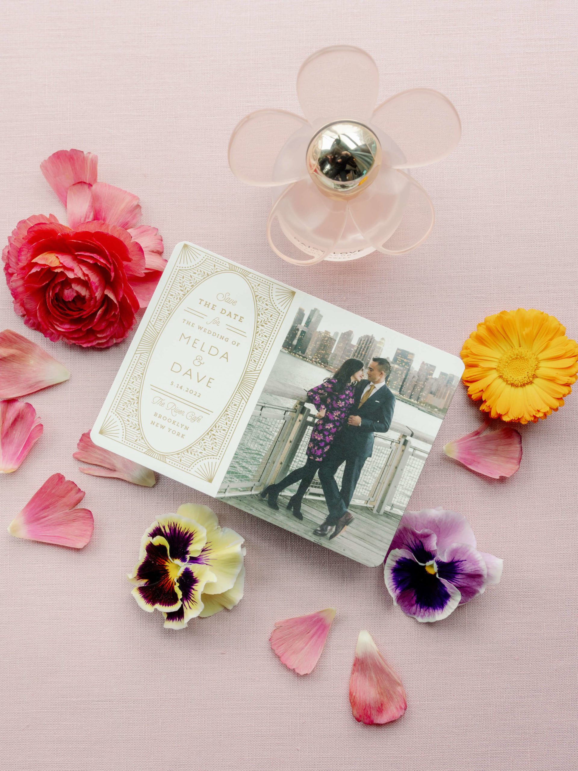 Pretty save-the-date card on a table with flowers. Editorial engagement photo by Jenny Fu Studio