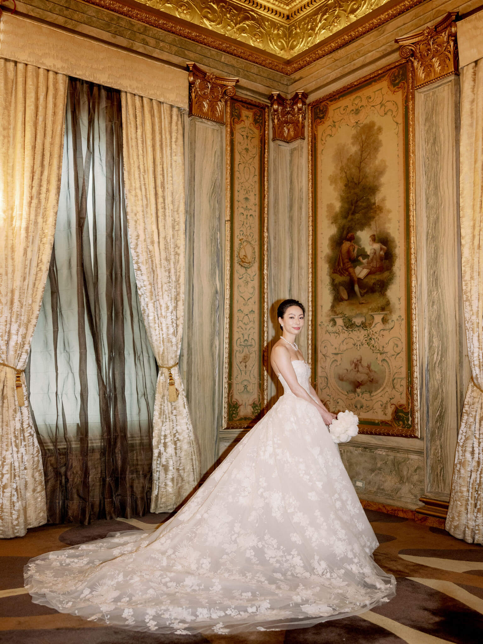 The bride is inside  Lotte New York Palace, with elegant interiors in the background. Image by Jenny Fu Studio