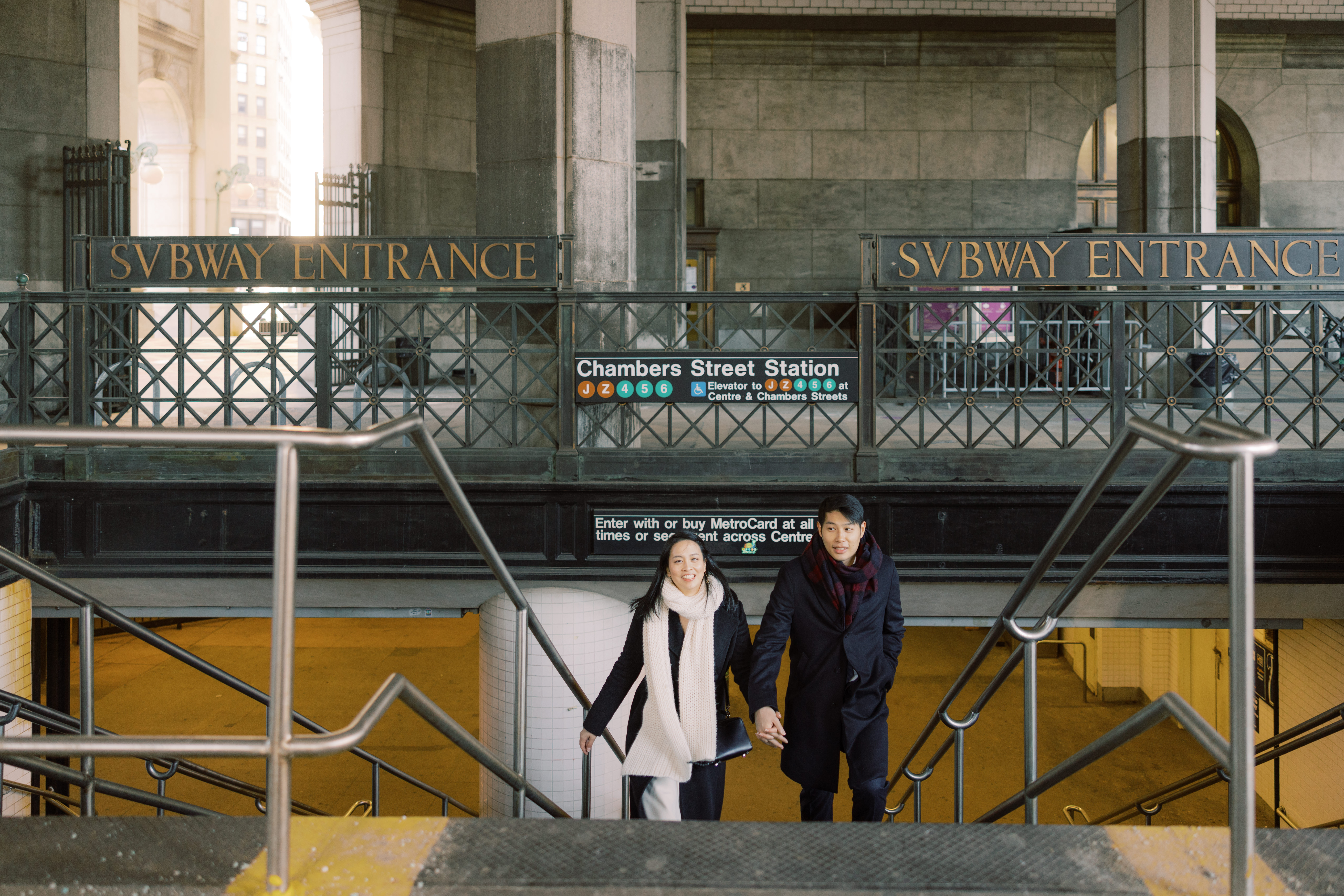 The couple is going up the stairs from a subway station. NYC City Hall wedding photos image by Jenny Fu Studio