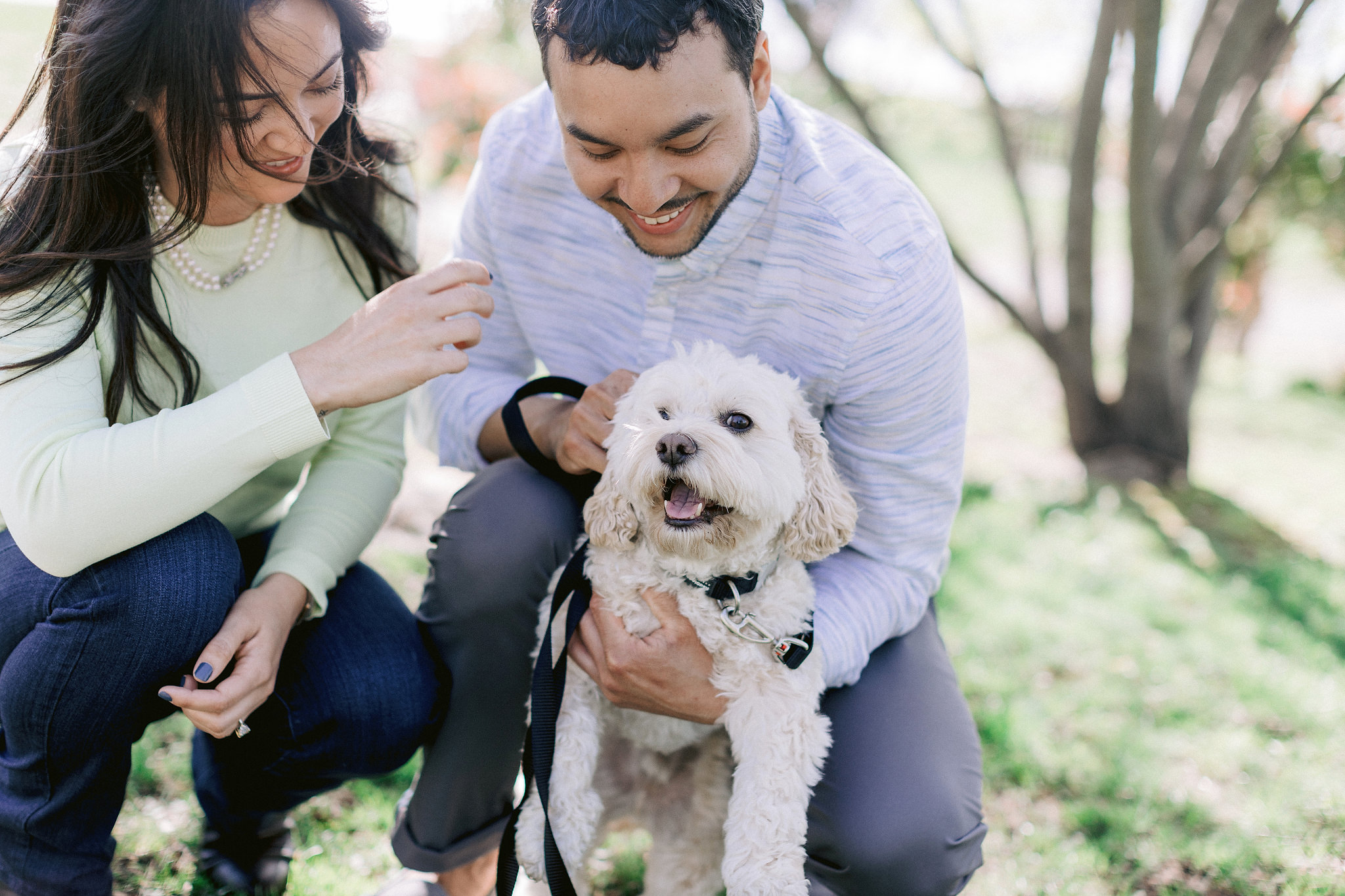 The engaged couple is cuddling their pet. Engagement session with pets photo by Jenny Fu Studio.