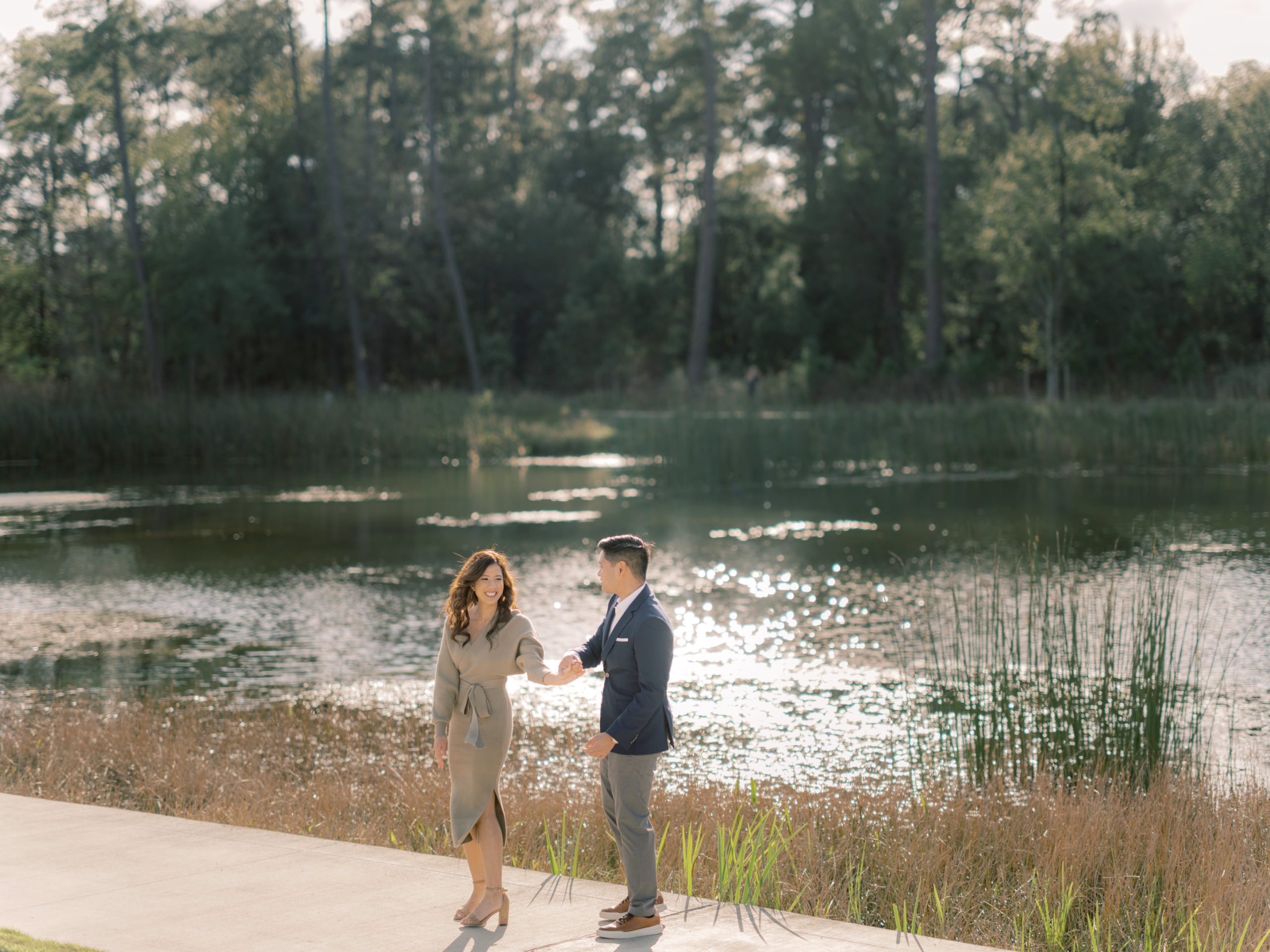 The engaged couple is happily hanging out with each other beside a lake. Image by Jenny Fu Studio