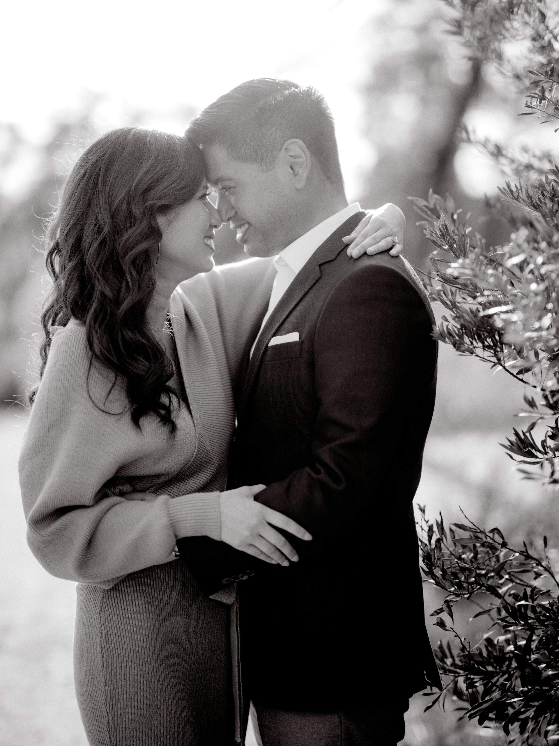 Black and white photo of the happily engaged couple standing close to each other, noses touching. Engagement photos by Jenny Fu Studio
