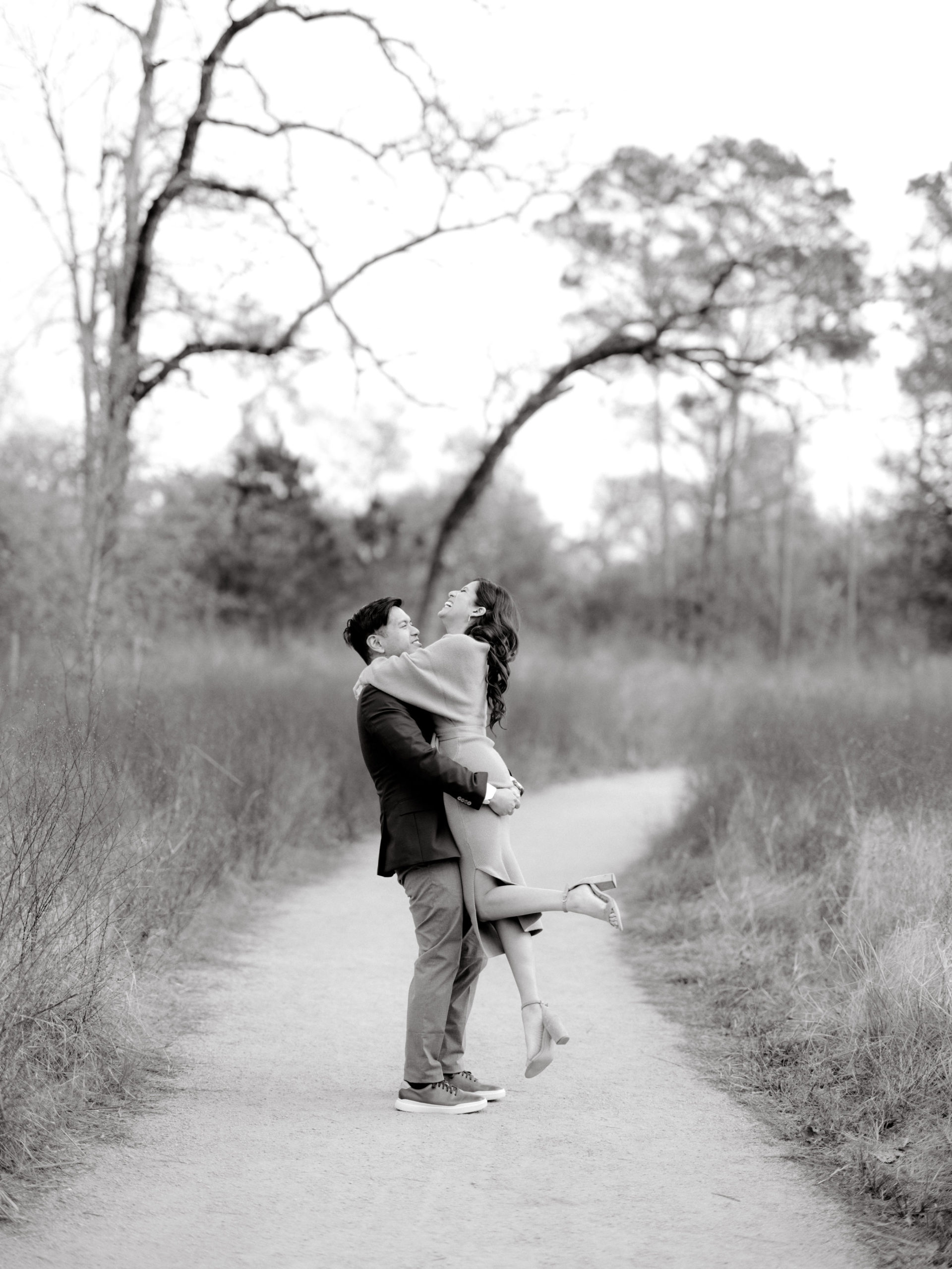 The man is carrying his fiancée, who is laughing. Editorial Engagement photos by Jenny Fu Studio