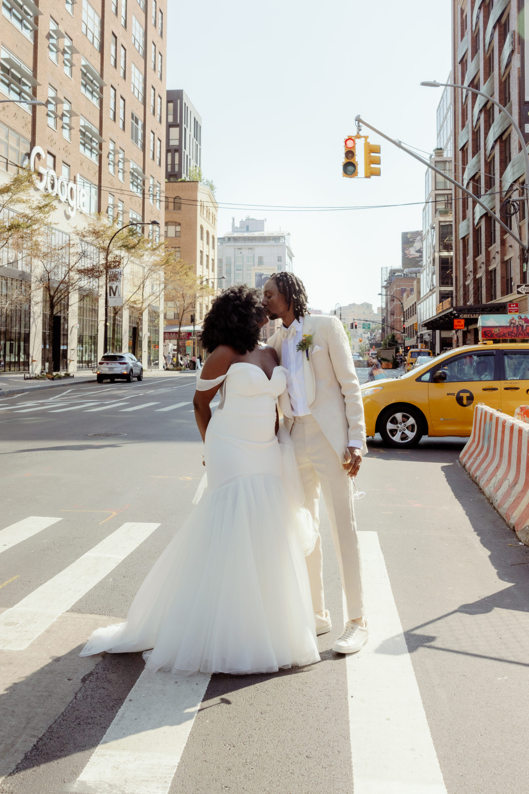 The newly-wed couple is kissing in the streets of NYC with a yellow cab in the background. Editorial elopement image by Jenny Fu Studio