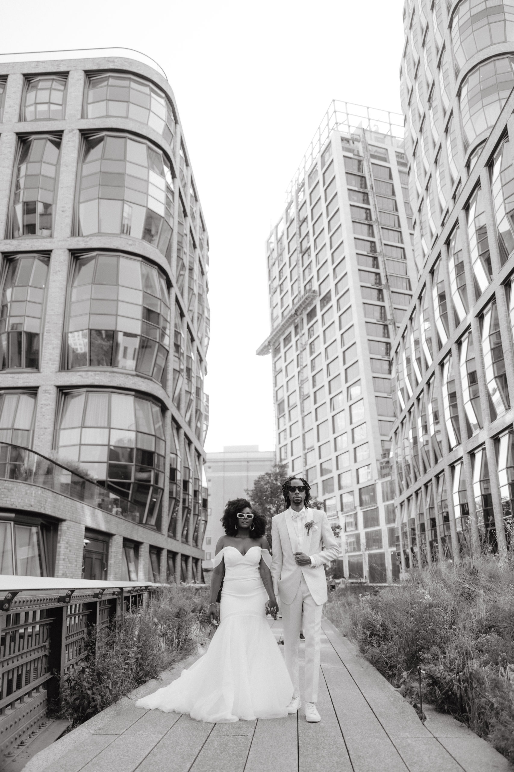 Black and white photo of the bride and groom with NYC skyscrapers in the background. Elopement image by Jenny Fu Studio