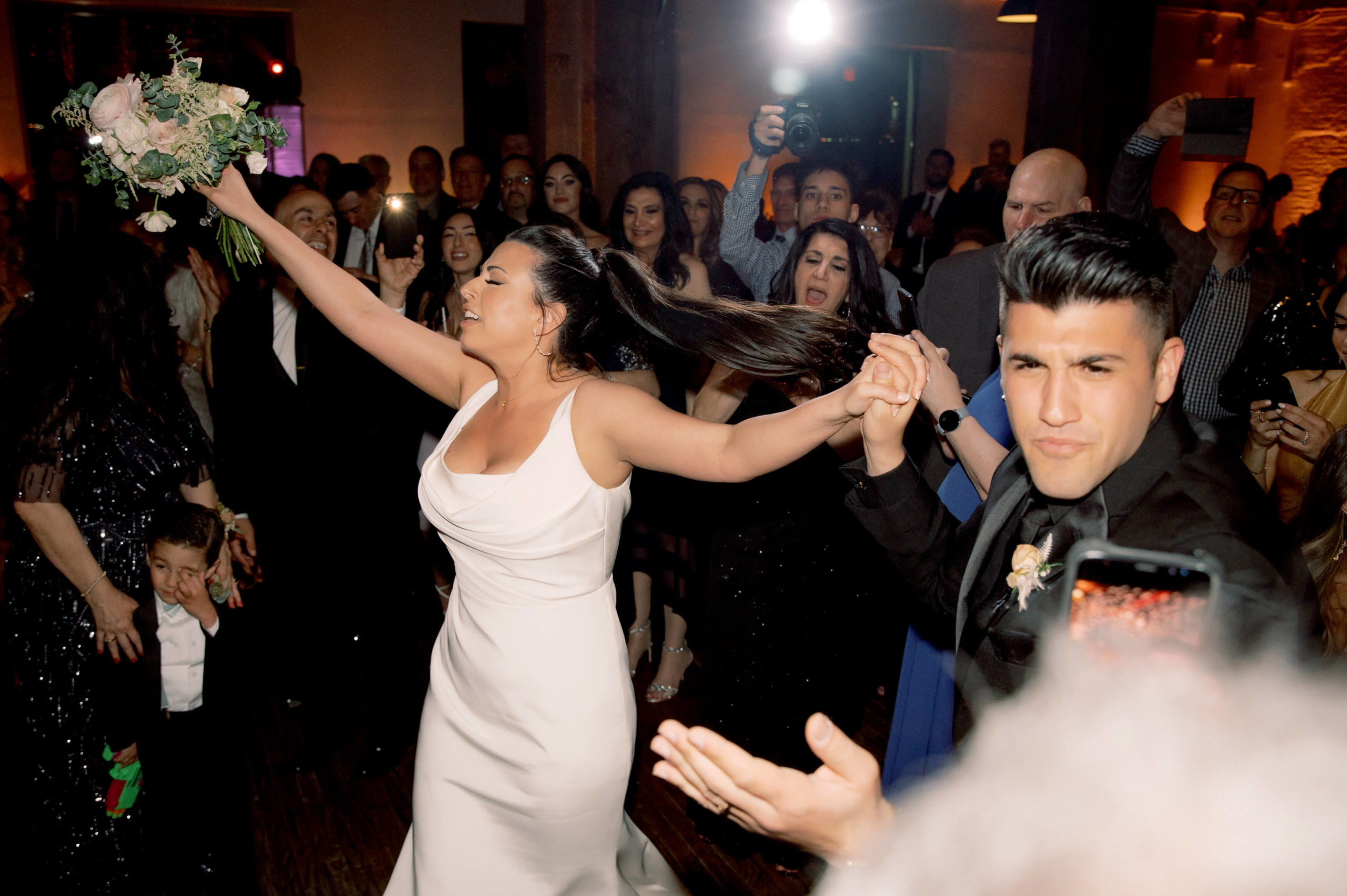 The newlyweds are dancing while the guests cheer on. Image by Jenny Fu Studio