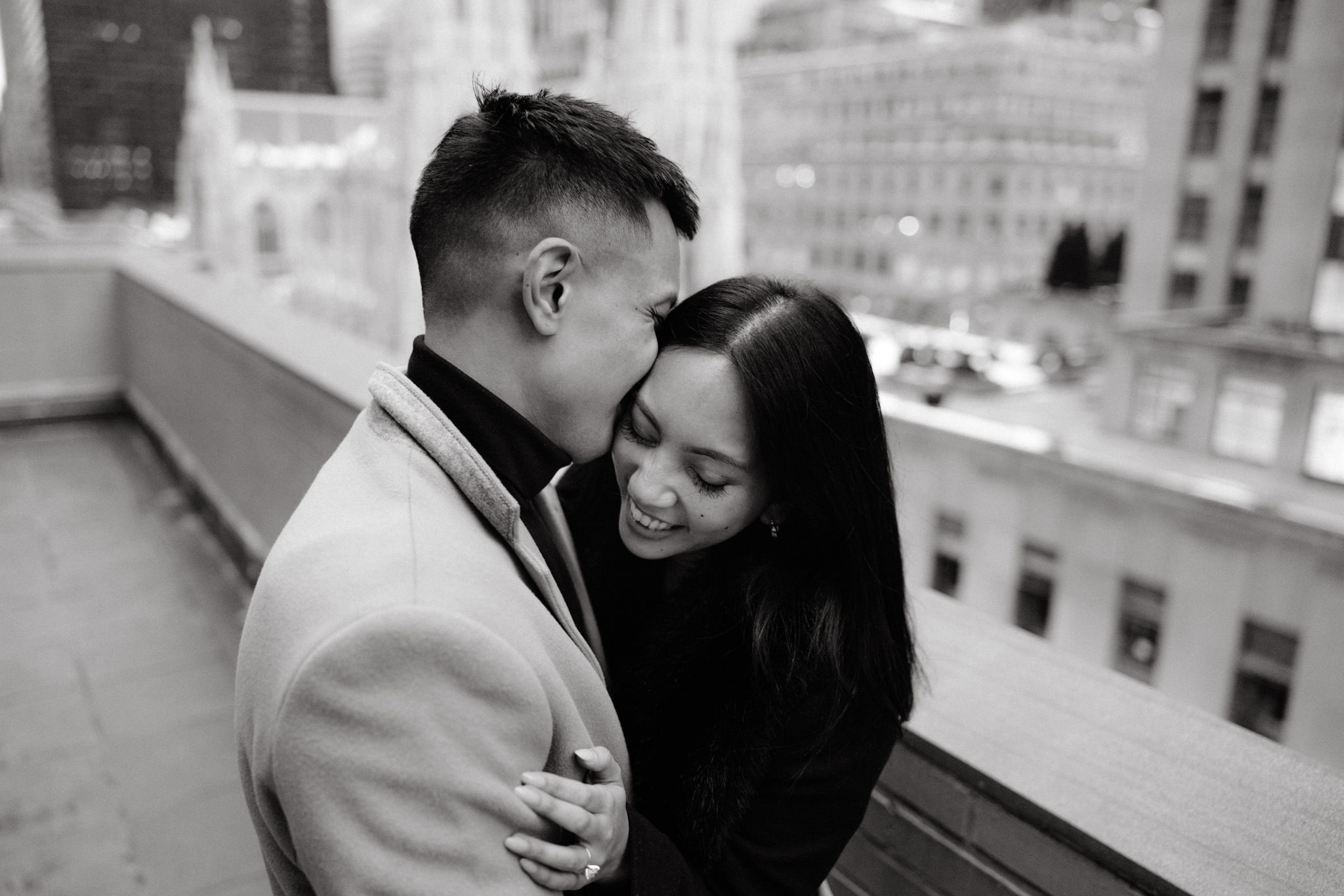 The man is kissing his fiancée on the cheek with St. Patrick's Cathedral in the background. Image by Jenny Fu Studio