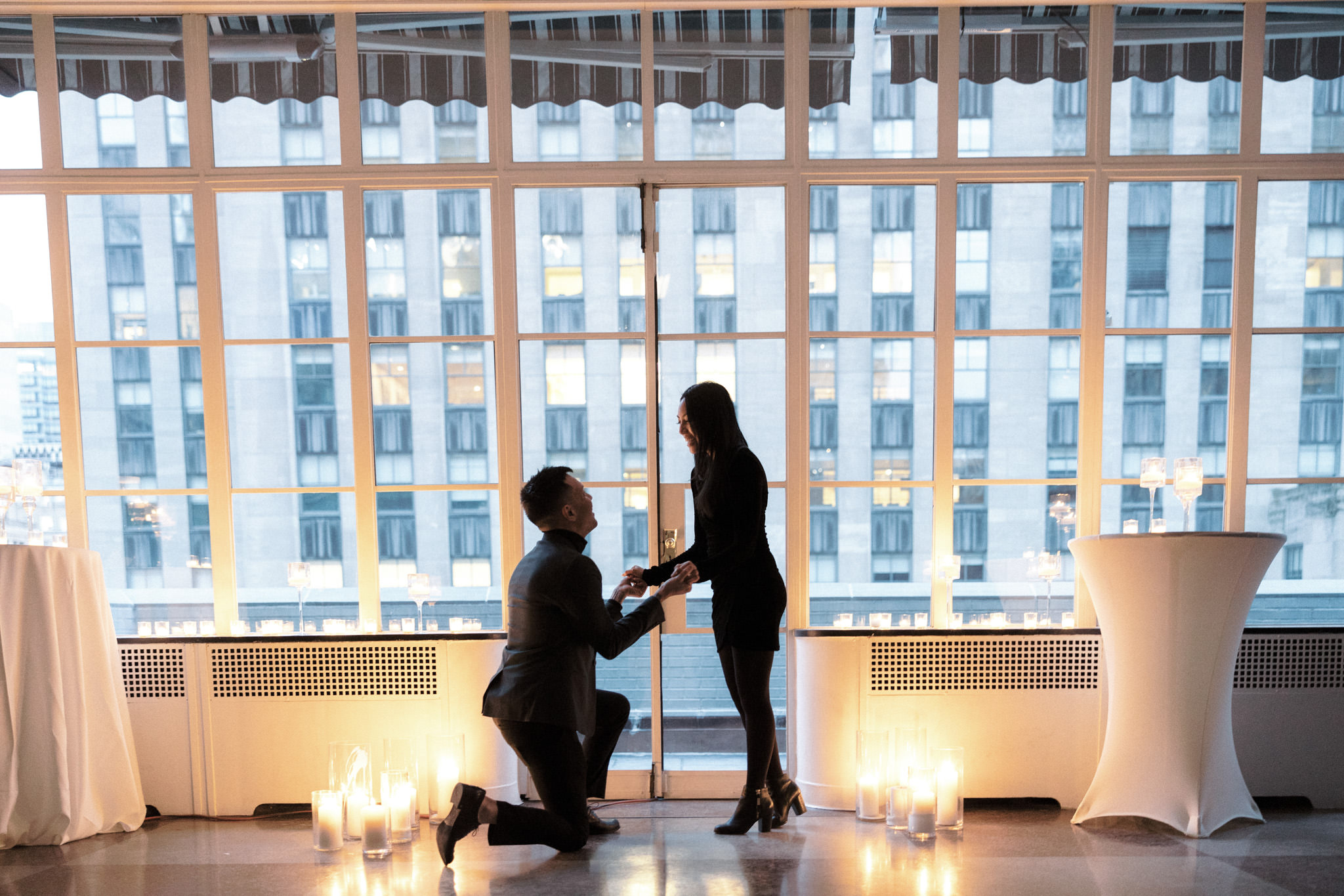 The man down on one knee while proposing to his future fiancée. Proposal in NYC image by Jenny Fu Studio  