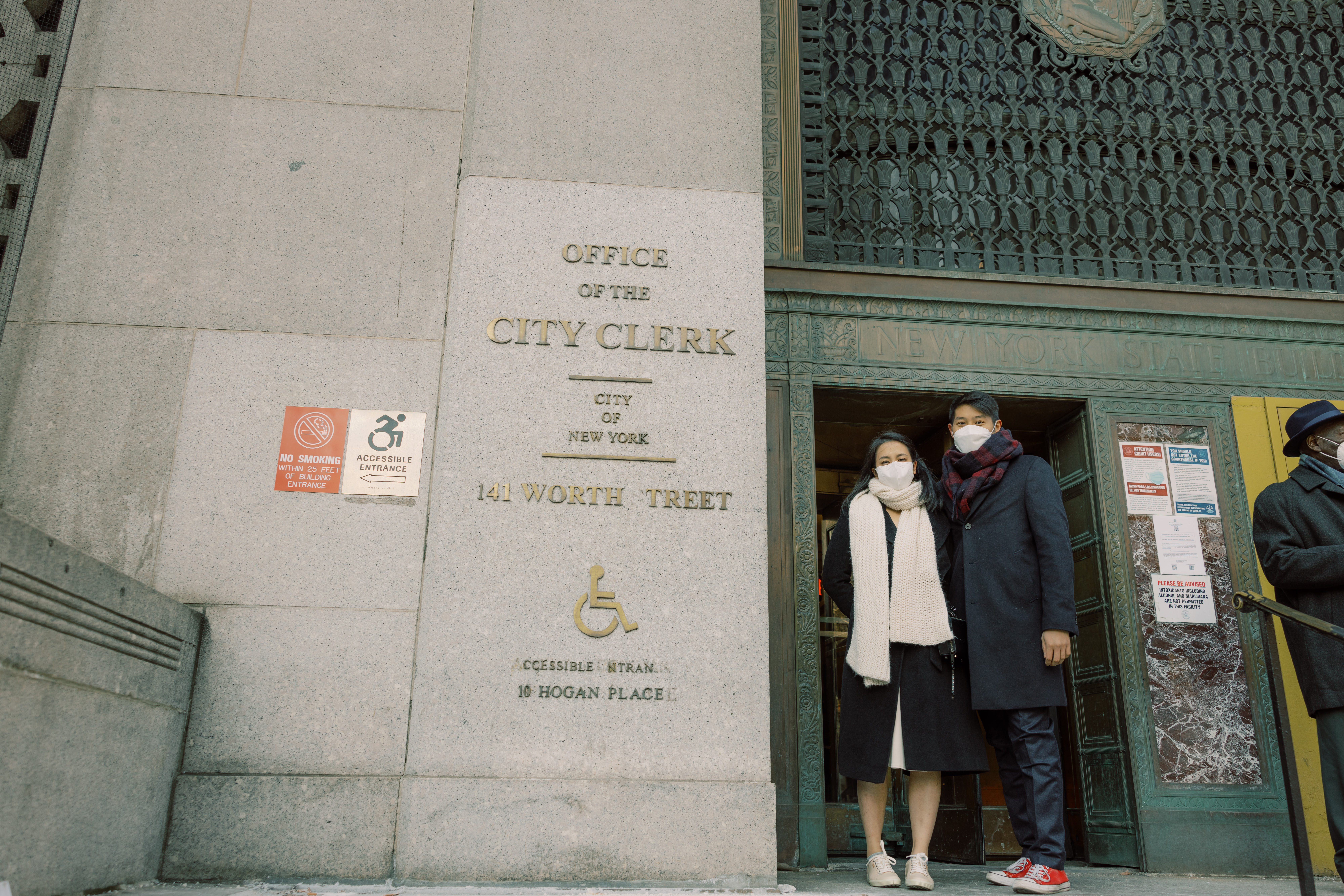The bride and groom are about to enter the Manhattan City Clerk Office. NYC Christmas elopement image by Jenny Fu Studio