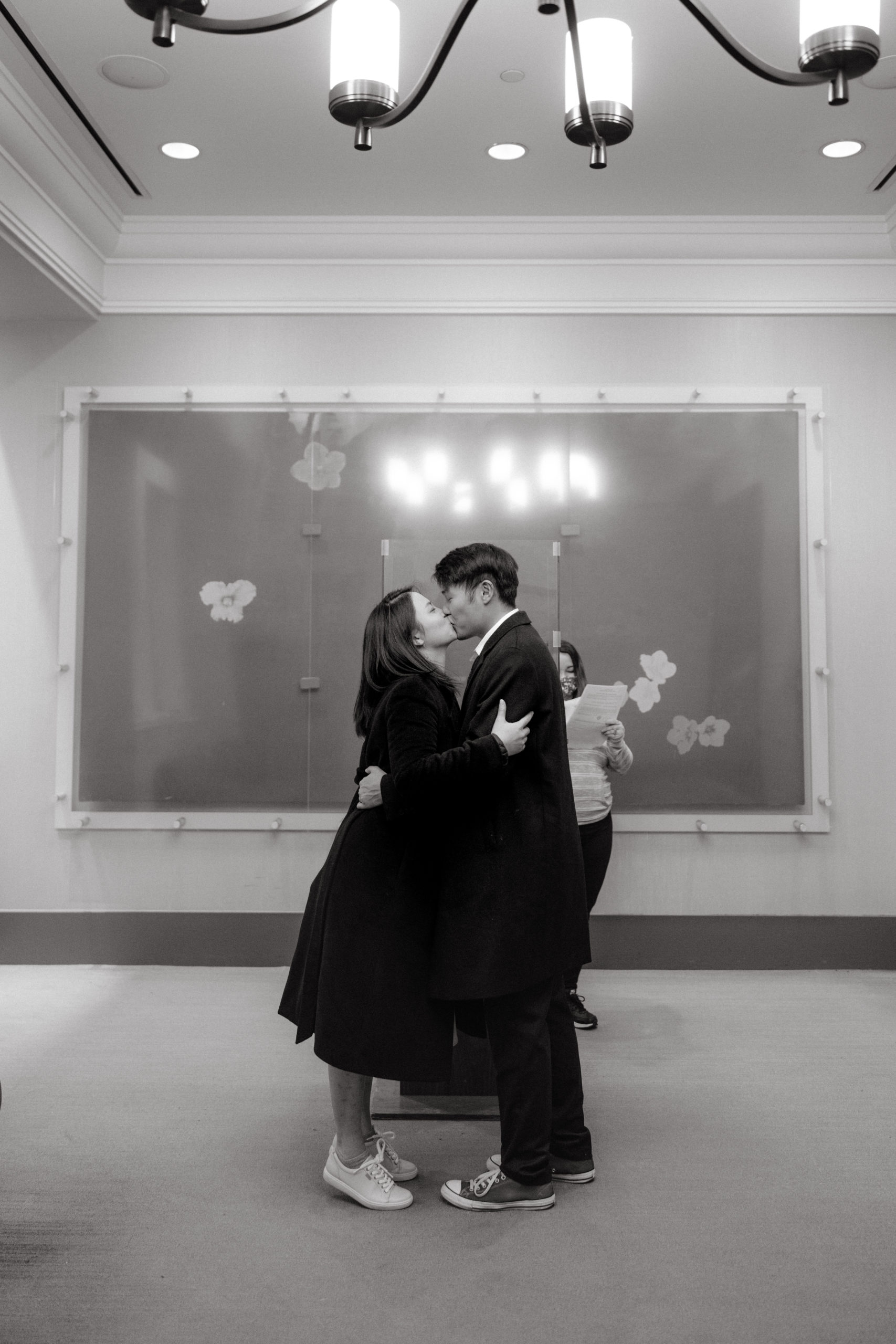 Black and white image of the newly-weds kissing after the wedding ceremony. NYC Christmas elopement image by Jenny Fu Studio