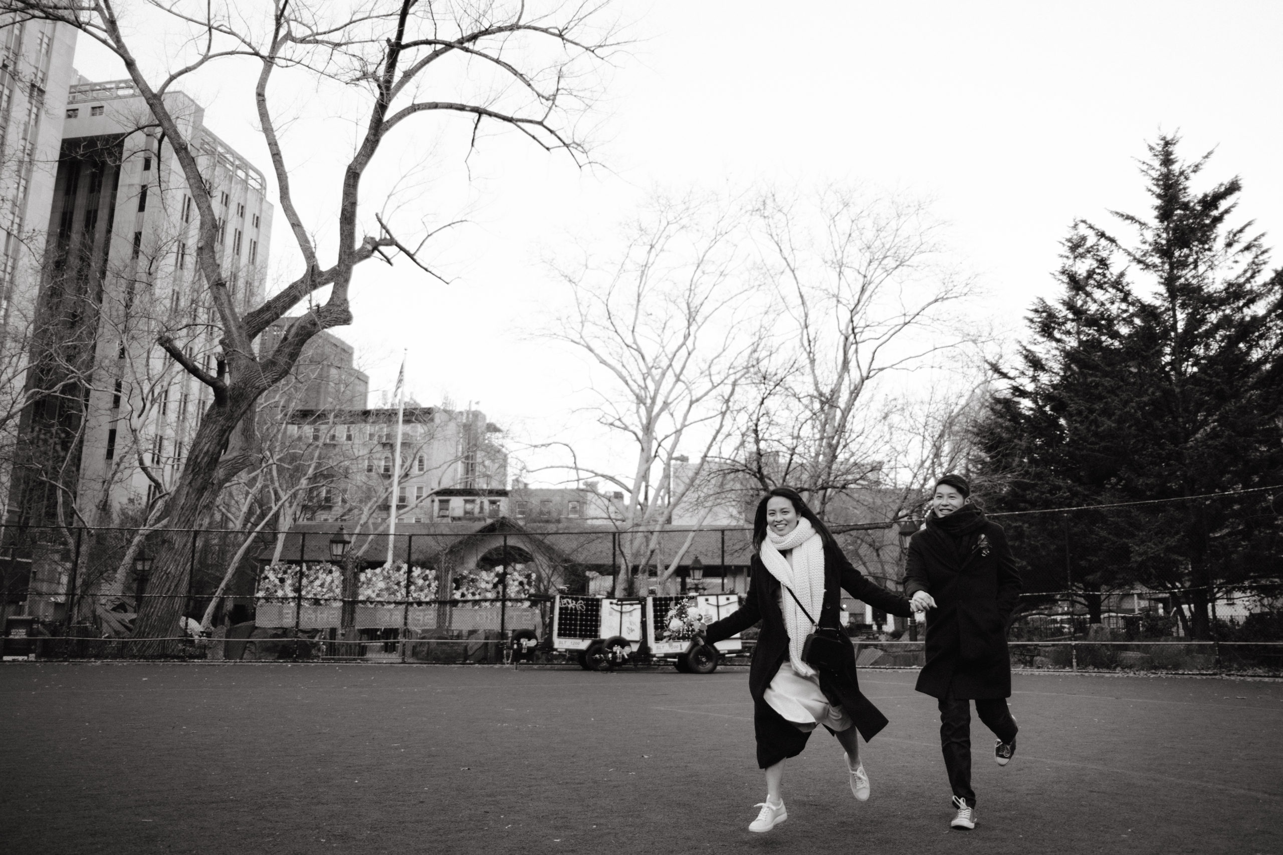 Editorial photo of the newly-weds running in a park. NYC Christmas elopement image by Jenny Fu Studio