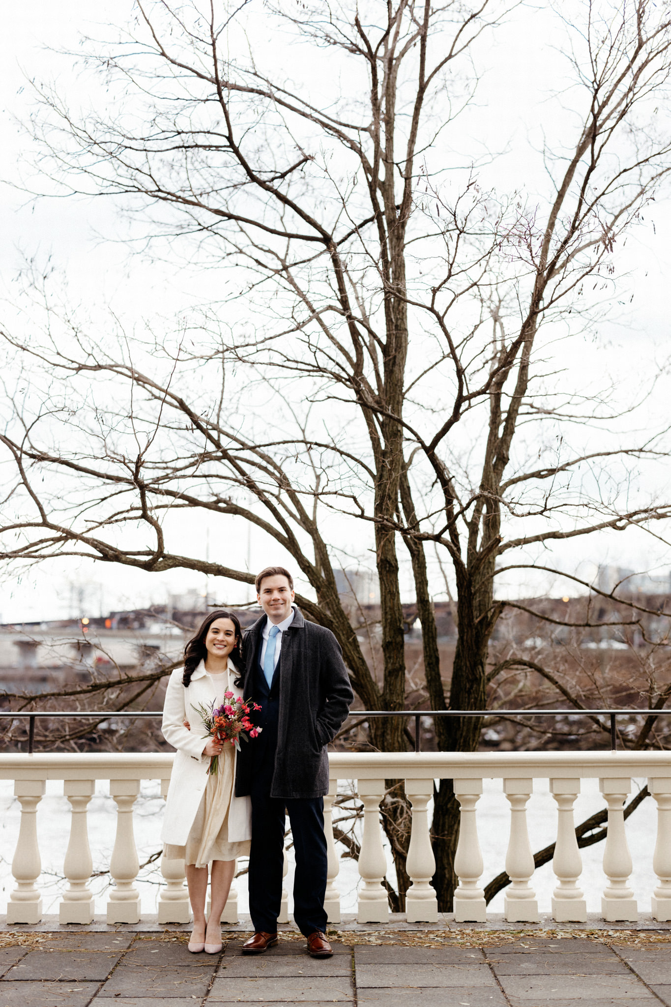 A wedding portrait of the newly-weds with a barren tree in the background. Winter wedding venues image by Jenny Fu Studio