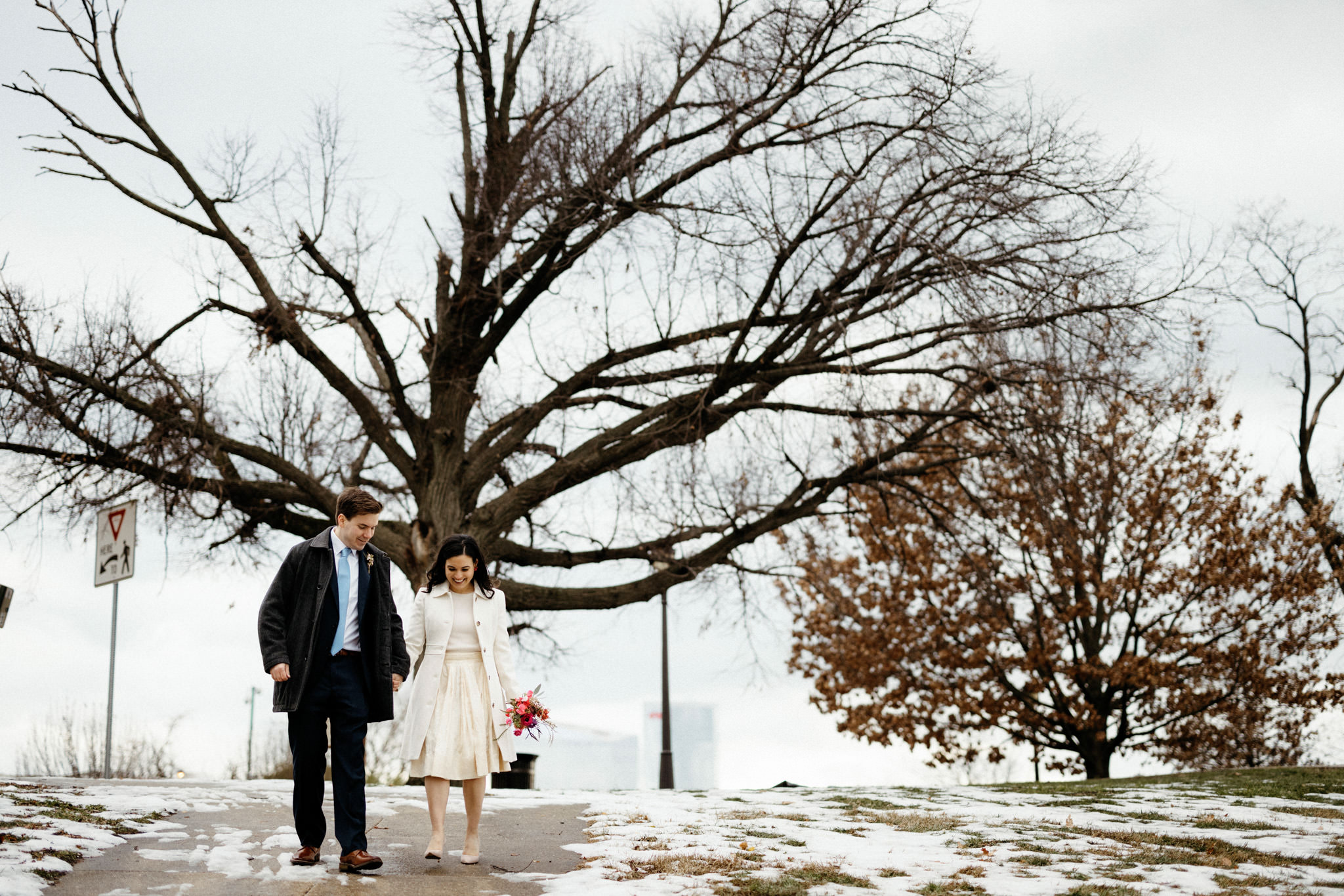 The newly-weds are happily walking in the snow. Winter wedding venues image by Jenny Fu Studio