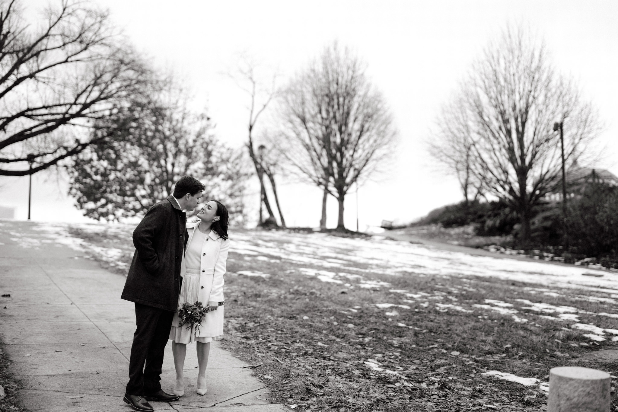 Black and white photo of the newly-weds romantically walking outdoors. Winter wedding venues image by Jenny Fu Studio