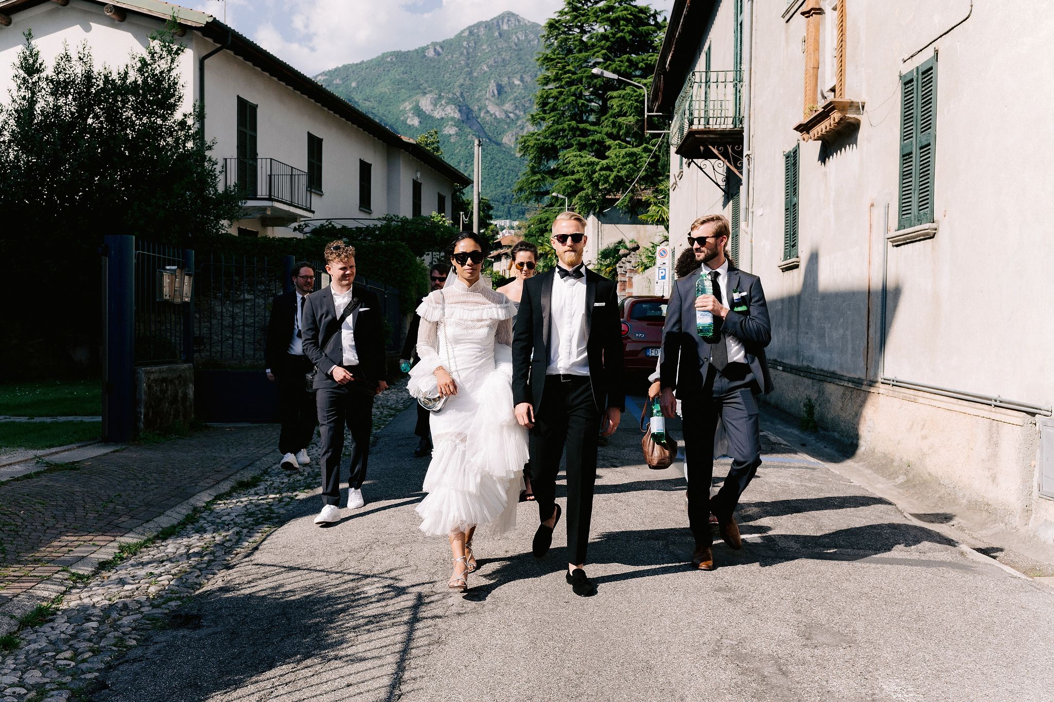 The bride and groom with their friends are walking the streets of Italy. Wedding in Italy image by Jenny Fu Studio