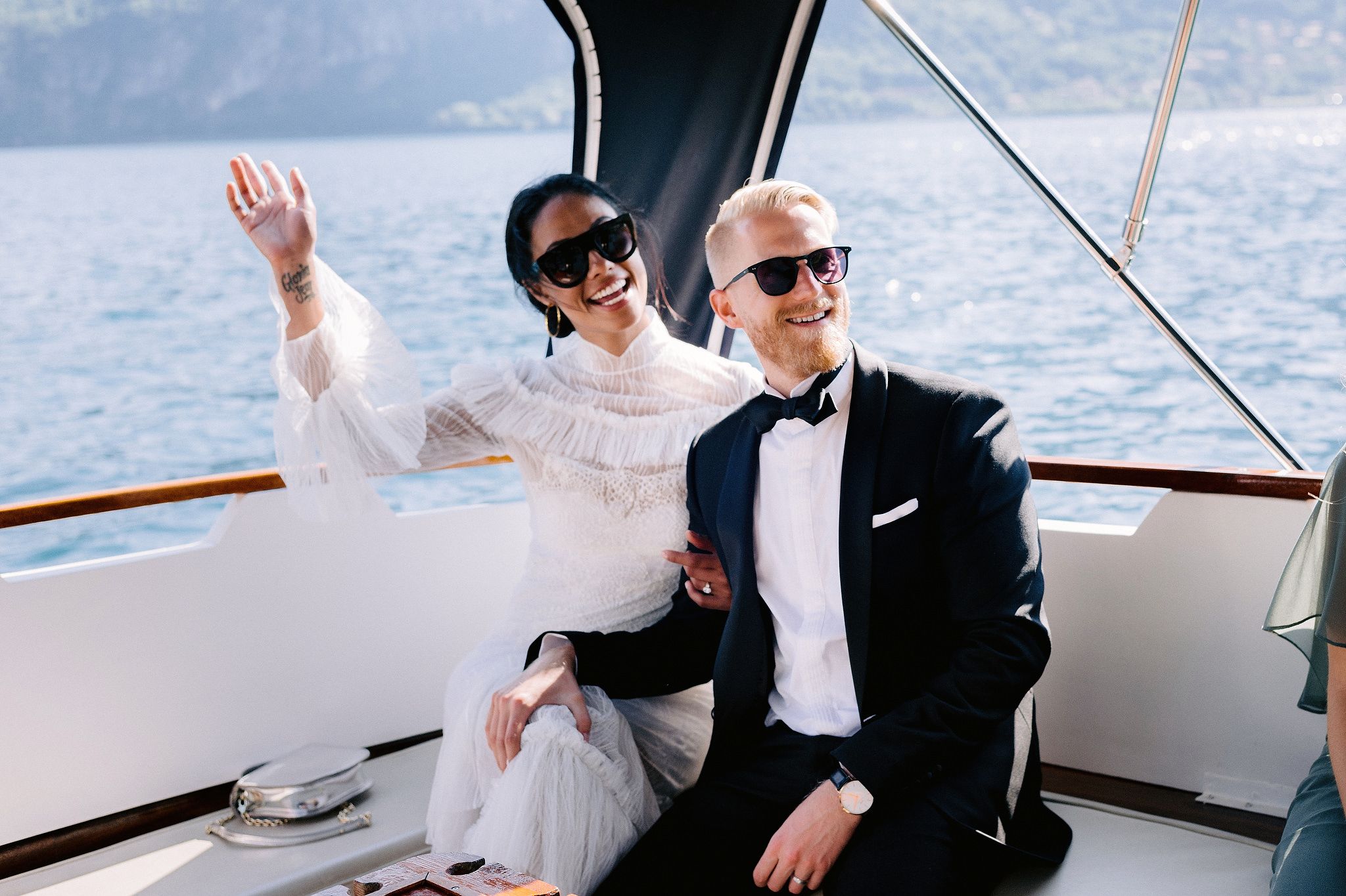 The bride and groom are happily riding a boat at Lake Como, Italy. Image by Jenny Fu Studio