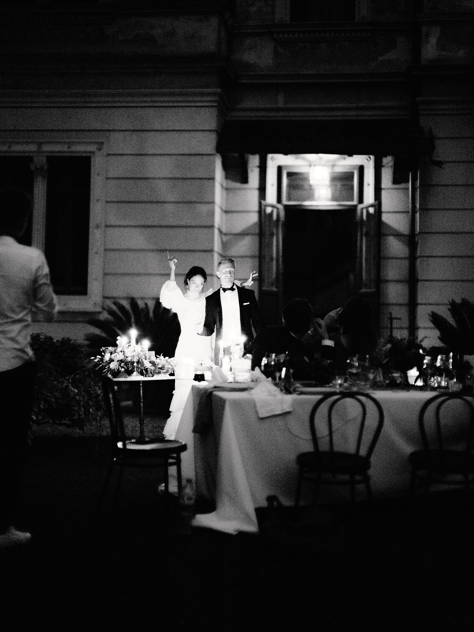 Black and white image of the bride and groom having a good time after dinner at Lake Como, Italy. Image by Jenny Fu Studio