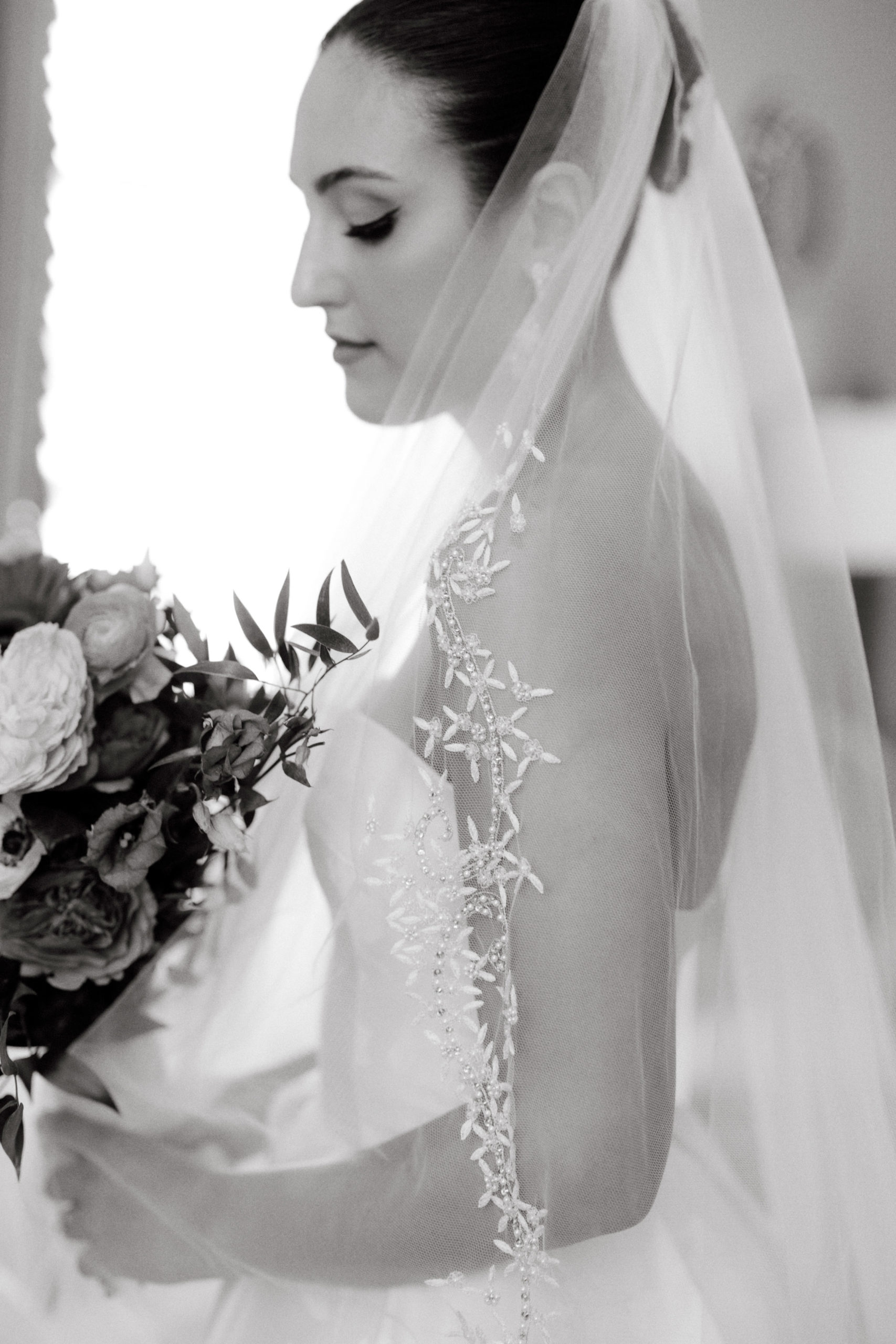 A side view, head shot, editorial image of a bride wearing a Reem Acra wedding dress. Image by Jenny Fu Studio