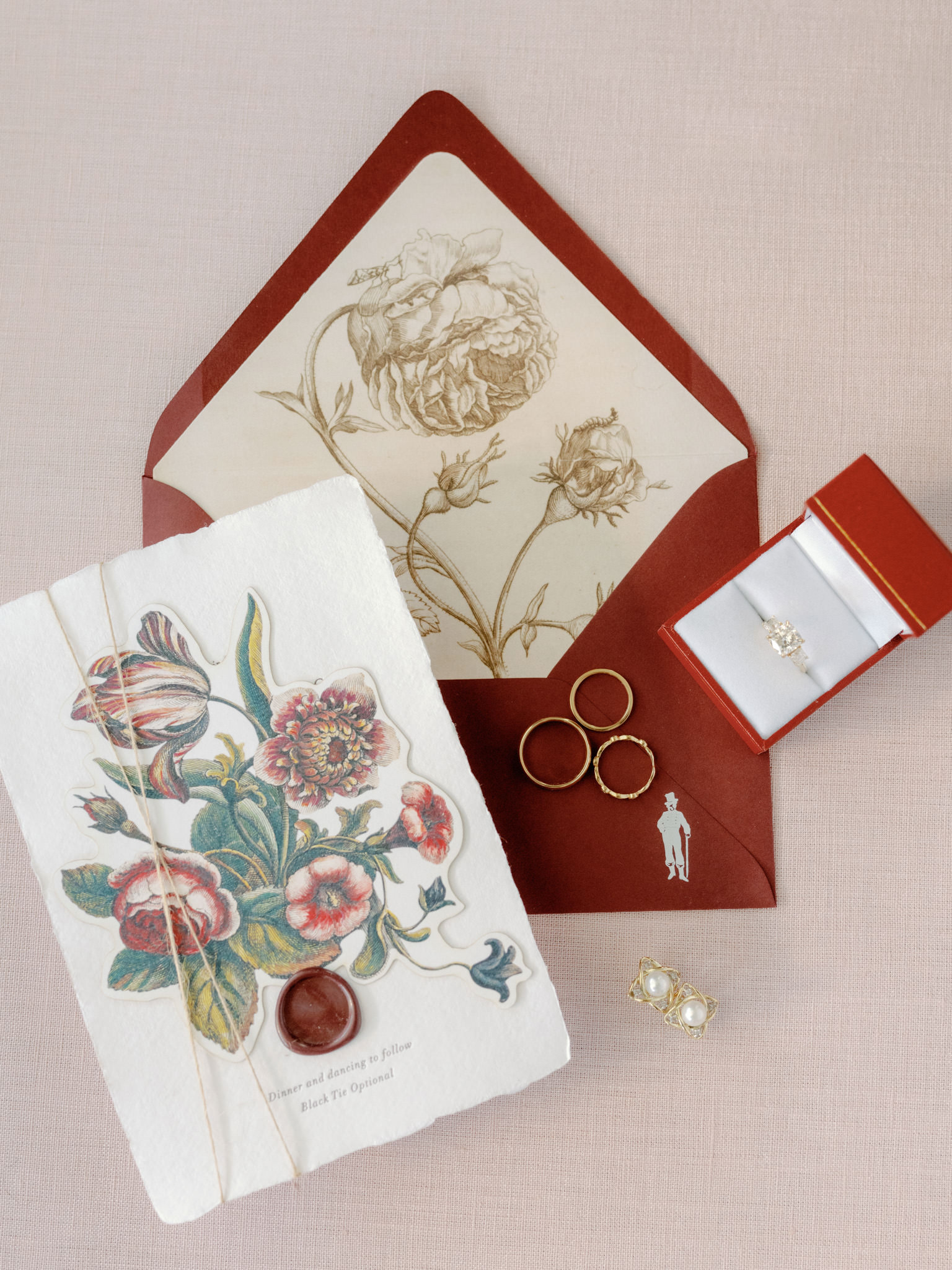 Photo of the couple's wedding invitation, wedding bands and accessories. Image by Jenny Fu Studio