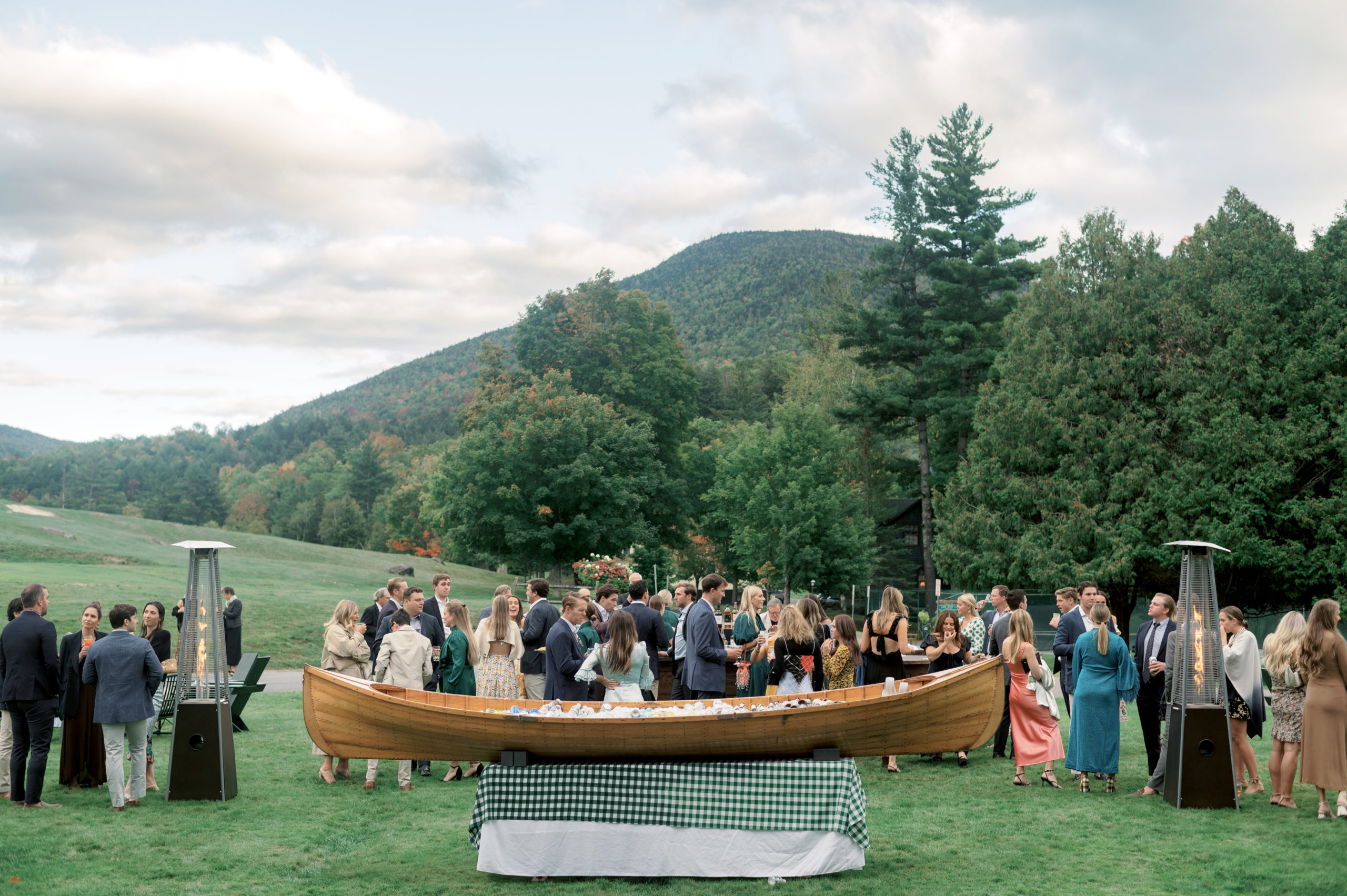 The wedding guests gather outdoors for a cocktail at The Ausable Club. Upstate NY wedding venues image by Jenny Fu Studio
