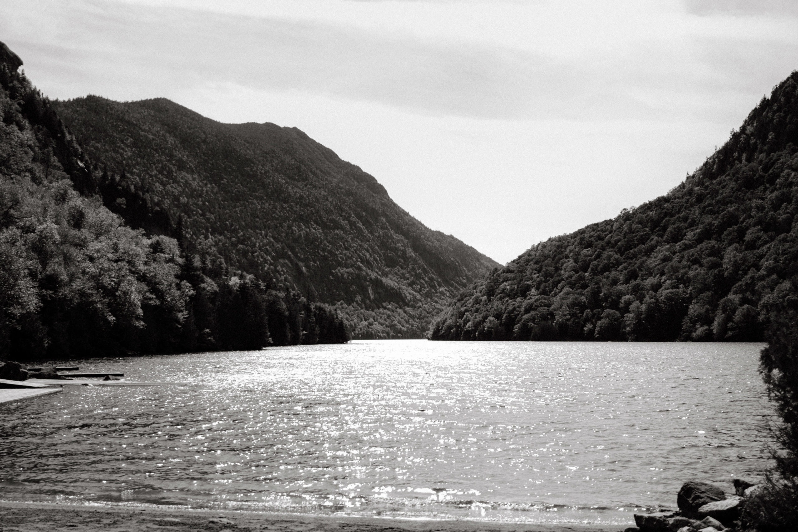 Black and white image of the lake and the Adirondack Mountains. Upstate NY wedding venues image by Jenny Fu Studio