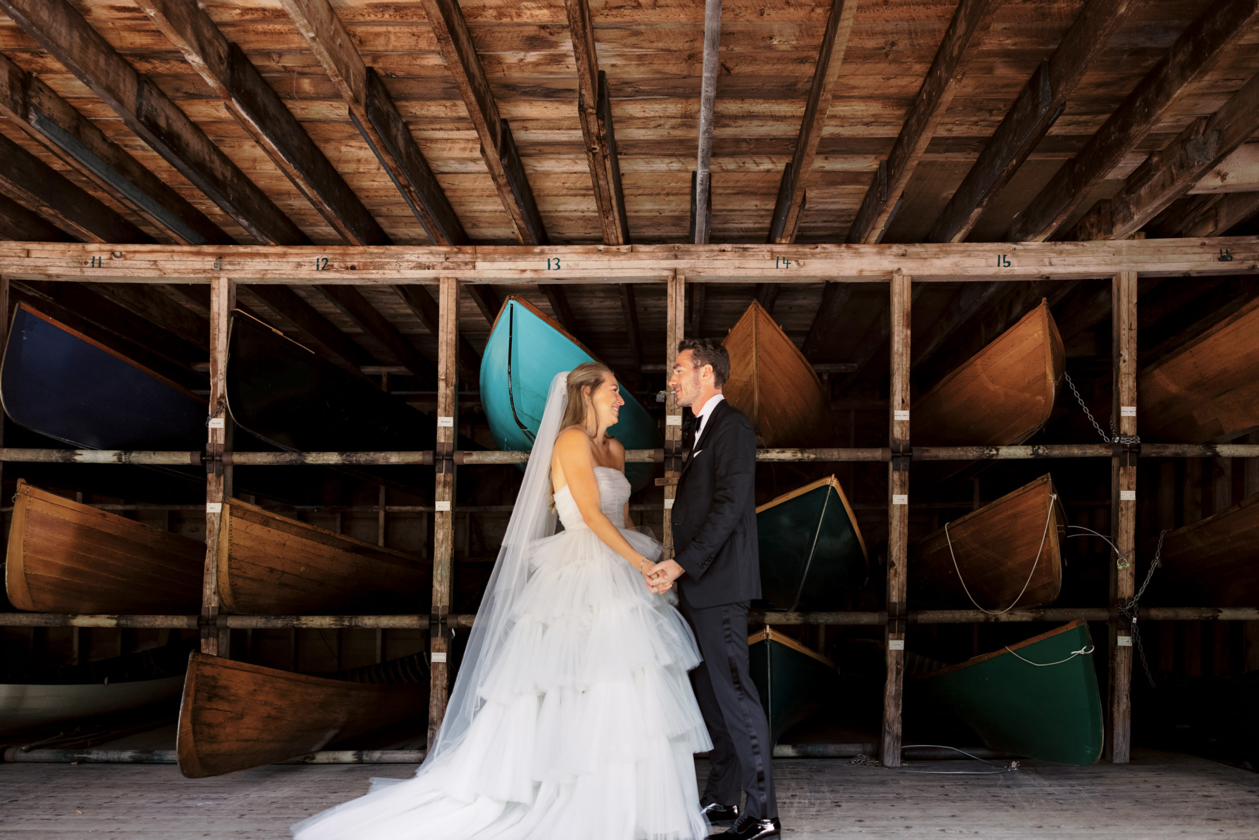 The bride and groom are happily staring at each other inside the boat house at The Ausable Club. Upstate NY wedding venues image by Jenny Fu Studio