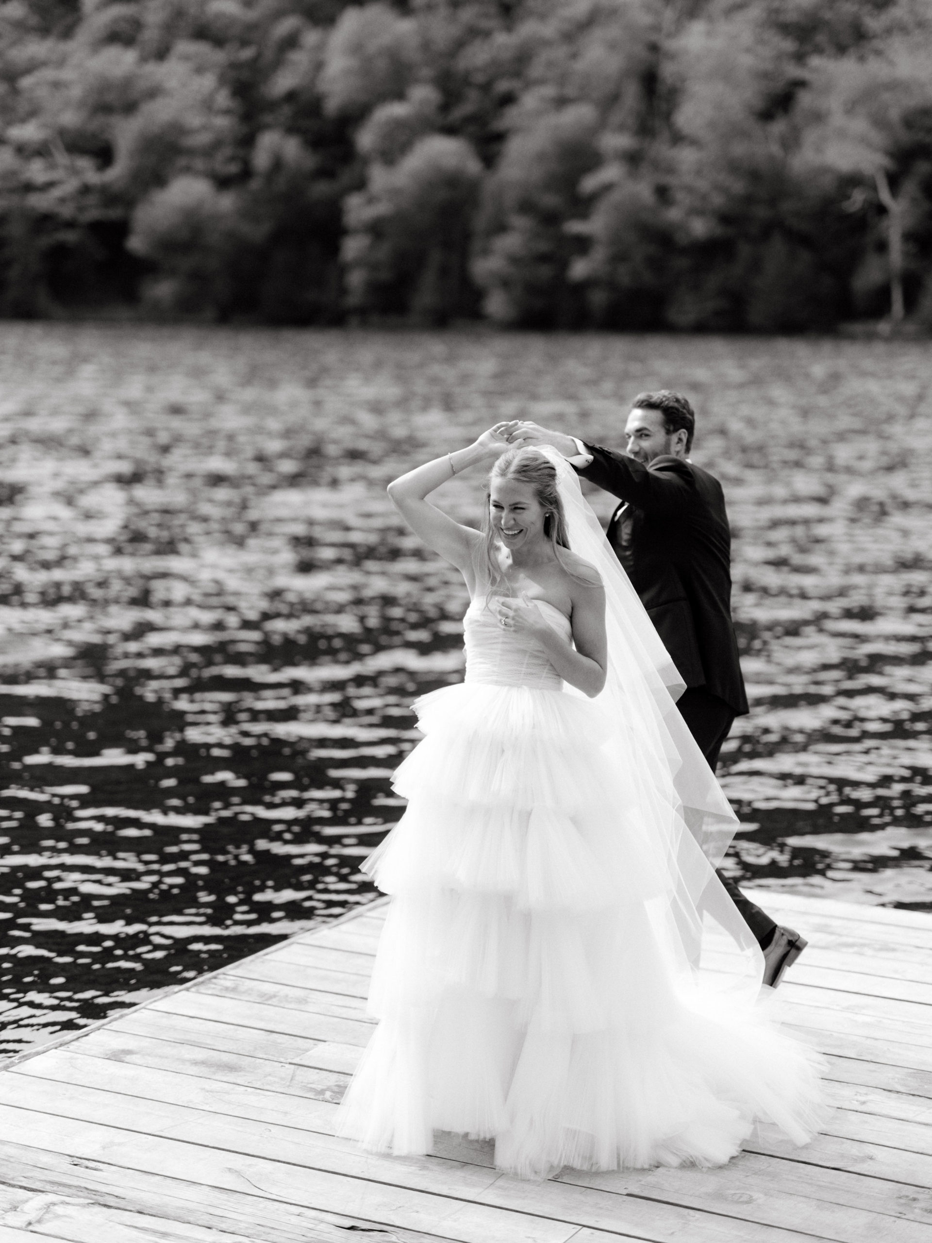 Editorial photo of the bride and groom dancing in the dock with the lake in the background at The Ausable Club. Upstate NY wedding venues image by Jenny Fu Studio