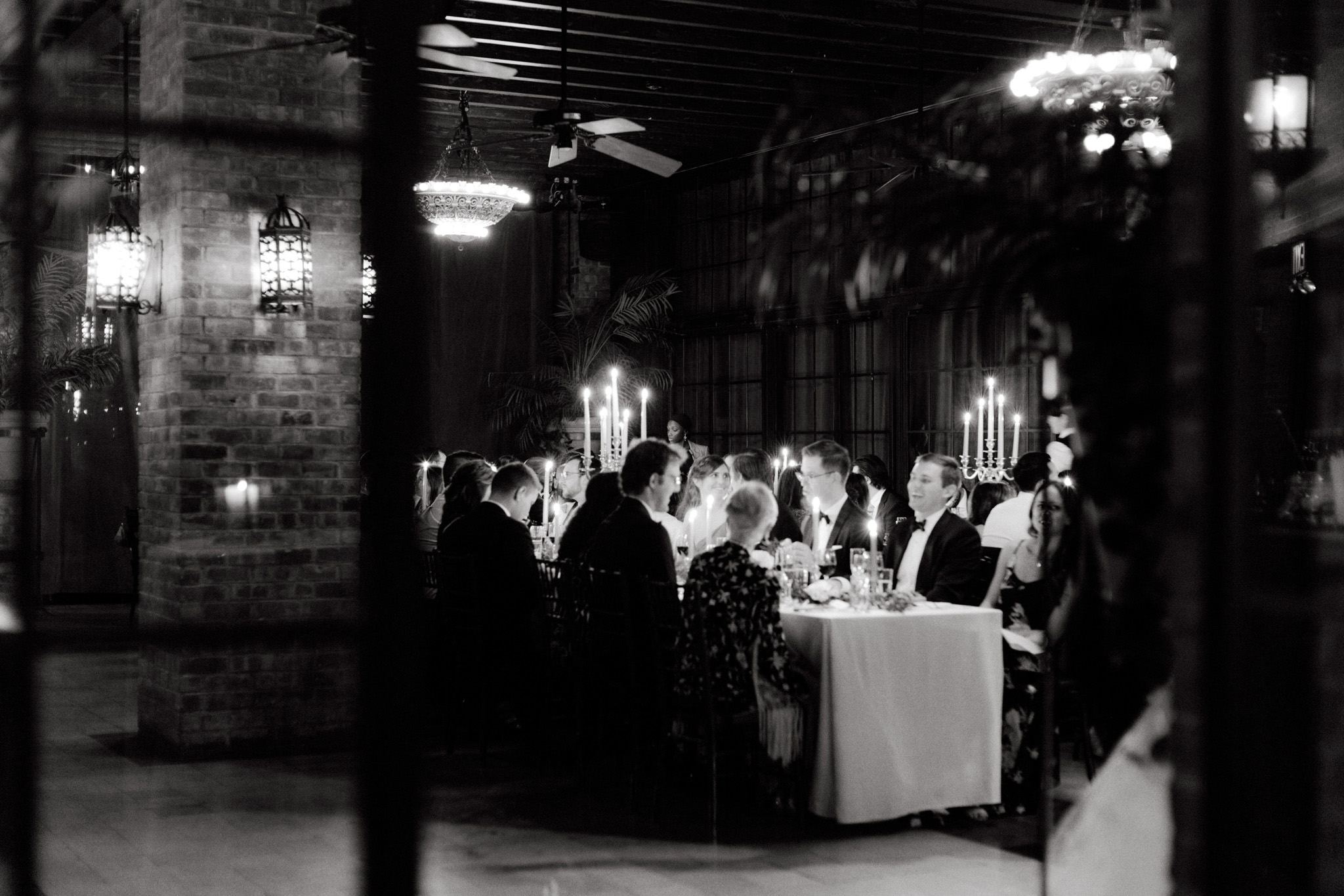 Black and white photo of the guests happily having dinner at a wedding reception at The Bowery Hotel. Image by Jenny Fu Studio