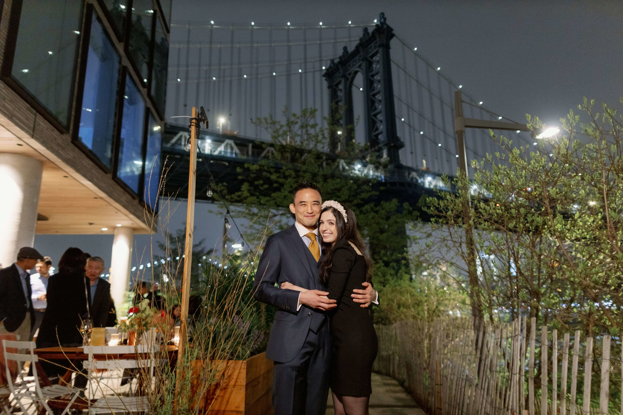 The bride and groom to be are happily hugging each other at a rehearsal dinner in The River Cafe NYC. Image by Jenny Fu Studio