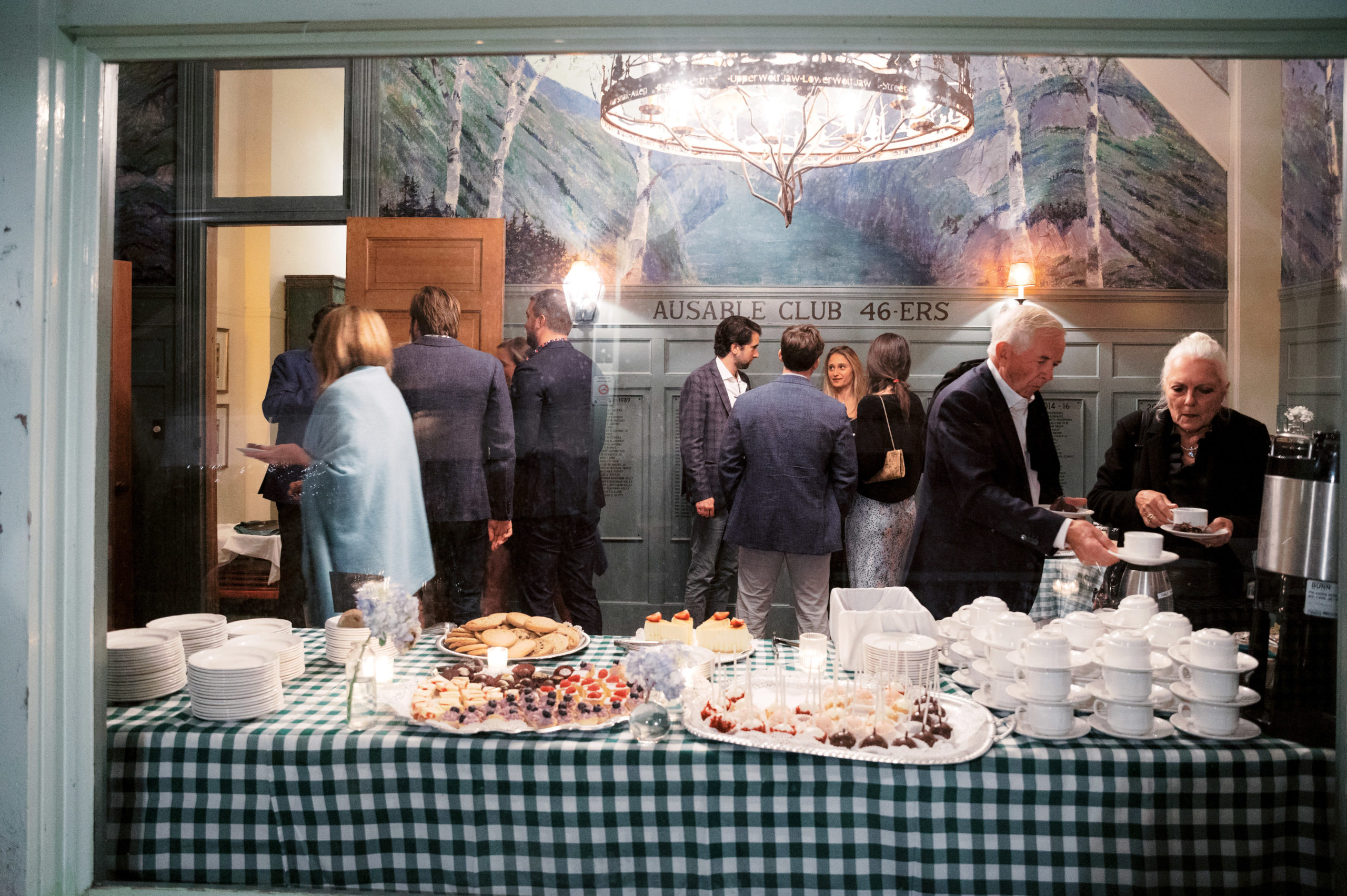 Guests are chatting with each other at a welcome dinner in The Ausable Club NY. Image by Jenny Fu Studio