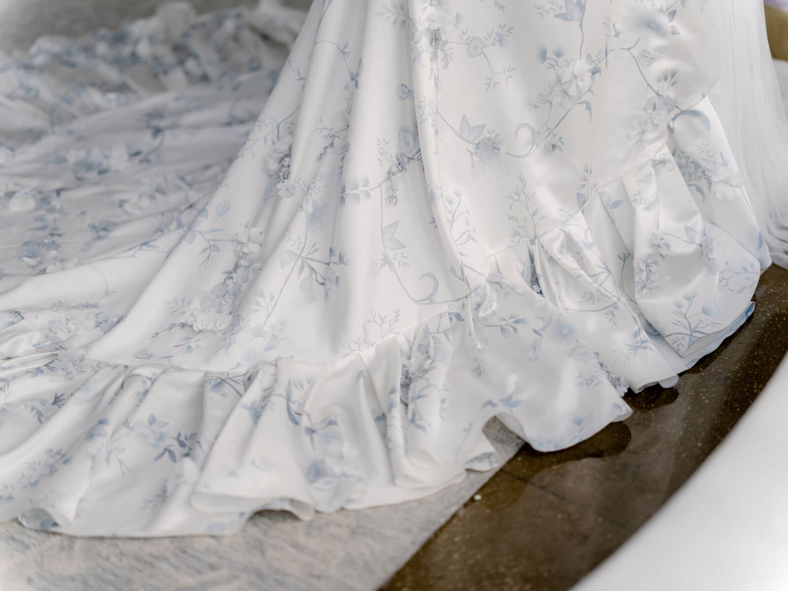 A ruffled hemline of an Alexandra Grecco wedding dress. Image by Jenny Fu Studio 